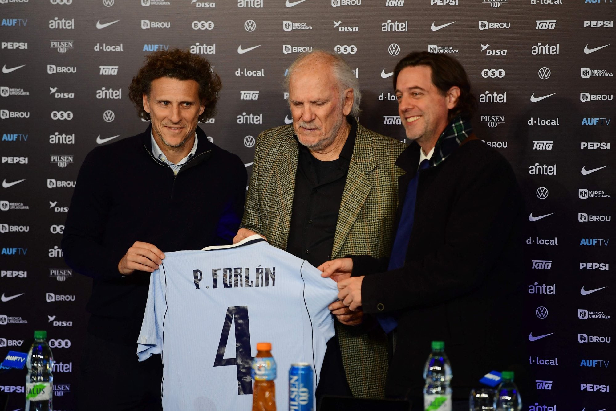 Diego Forlan y una imagen con emoción, junto con Pablo, su padre, y el presidente de la Asociación Uruguaya, Ignacio Alonso, durante la presentación en el estadio Centenario