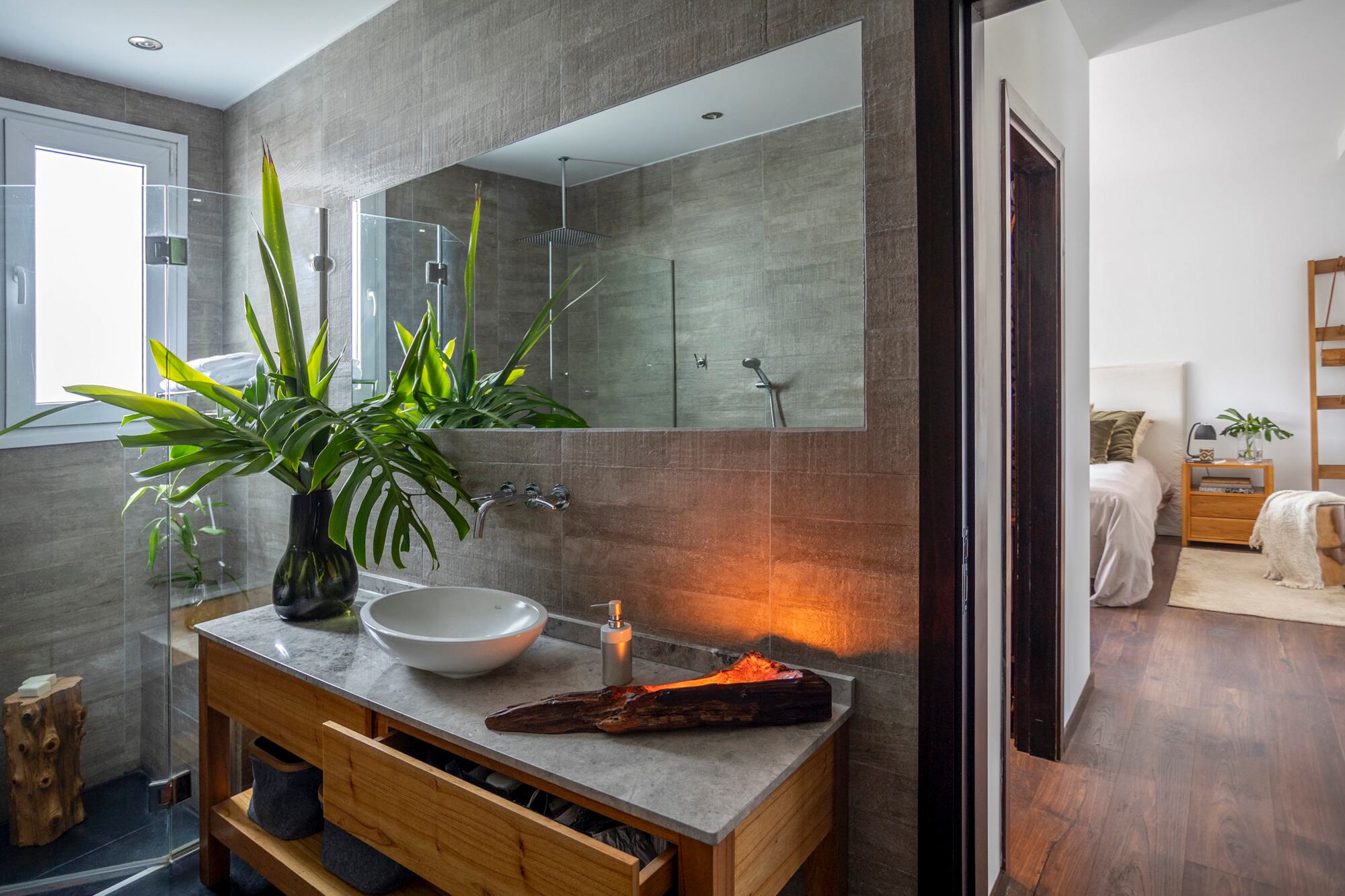 En el baño se hizo un mueble a medida de madera y tapa de mármol con bacha apoyada.