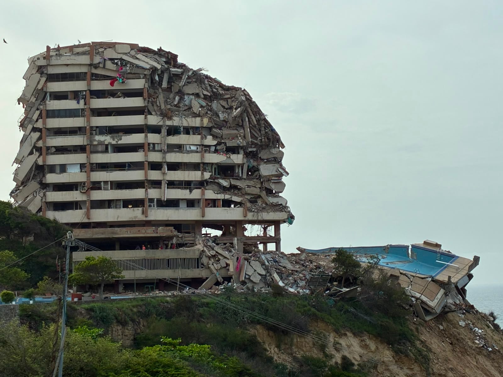 Una pileta se asoma al precipicio junto al derrumbado edificio al que pertenecía