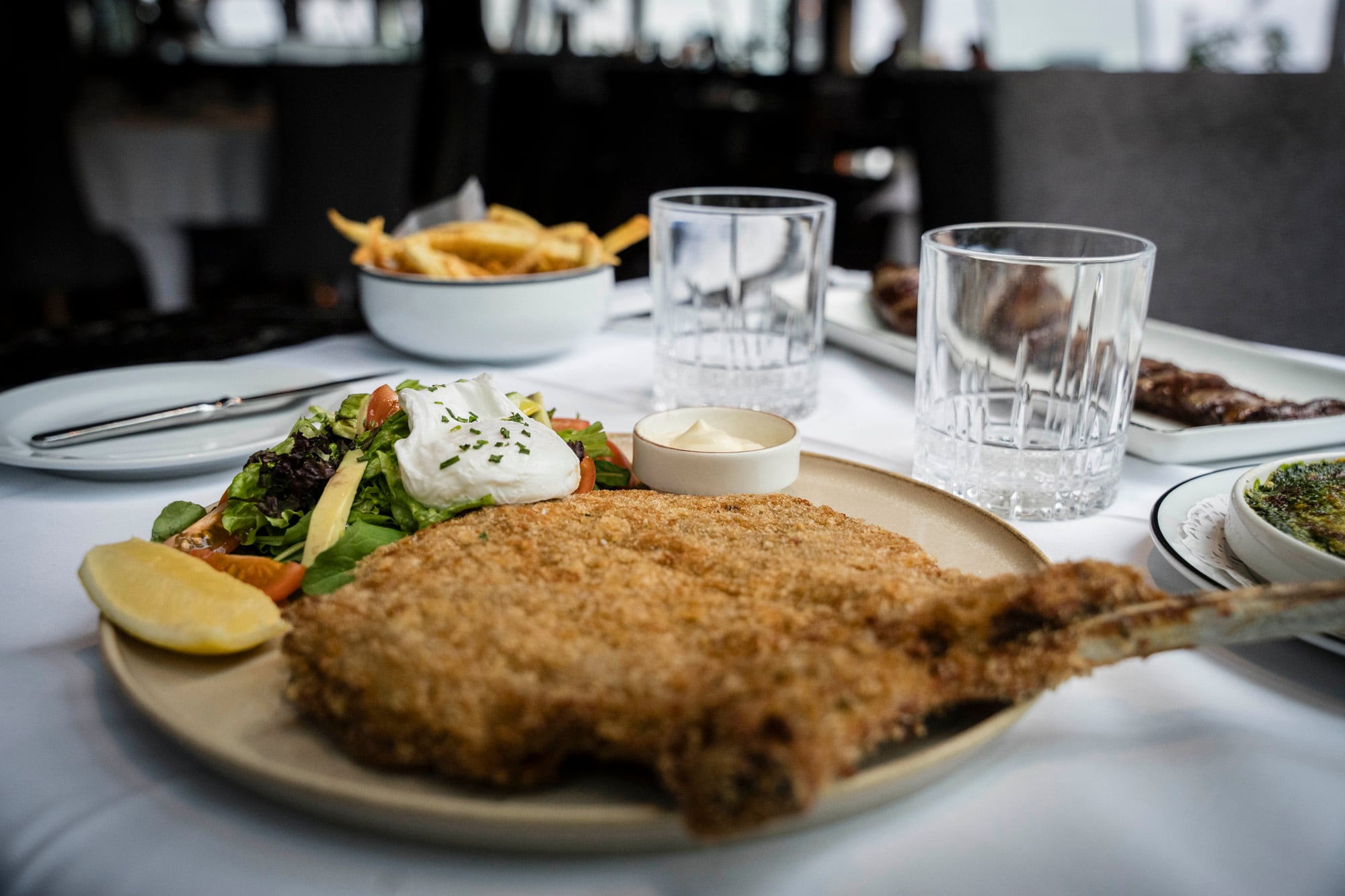 La milanesa de bife con hueso y alioli de limón, un imperdible de Happening