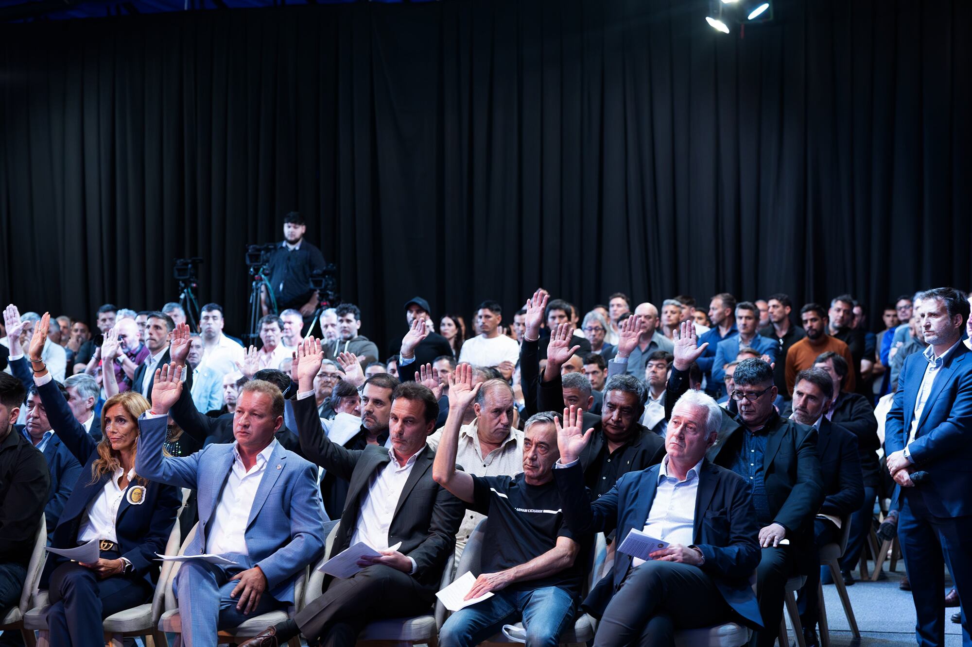 Los dirigentes en la Asamblea General Ordinaria 2024 de la Asociación del Fútbol Argentino en el predio de Ezeiza, y un voto a mano alzada