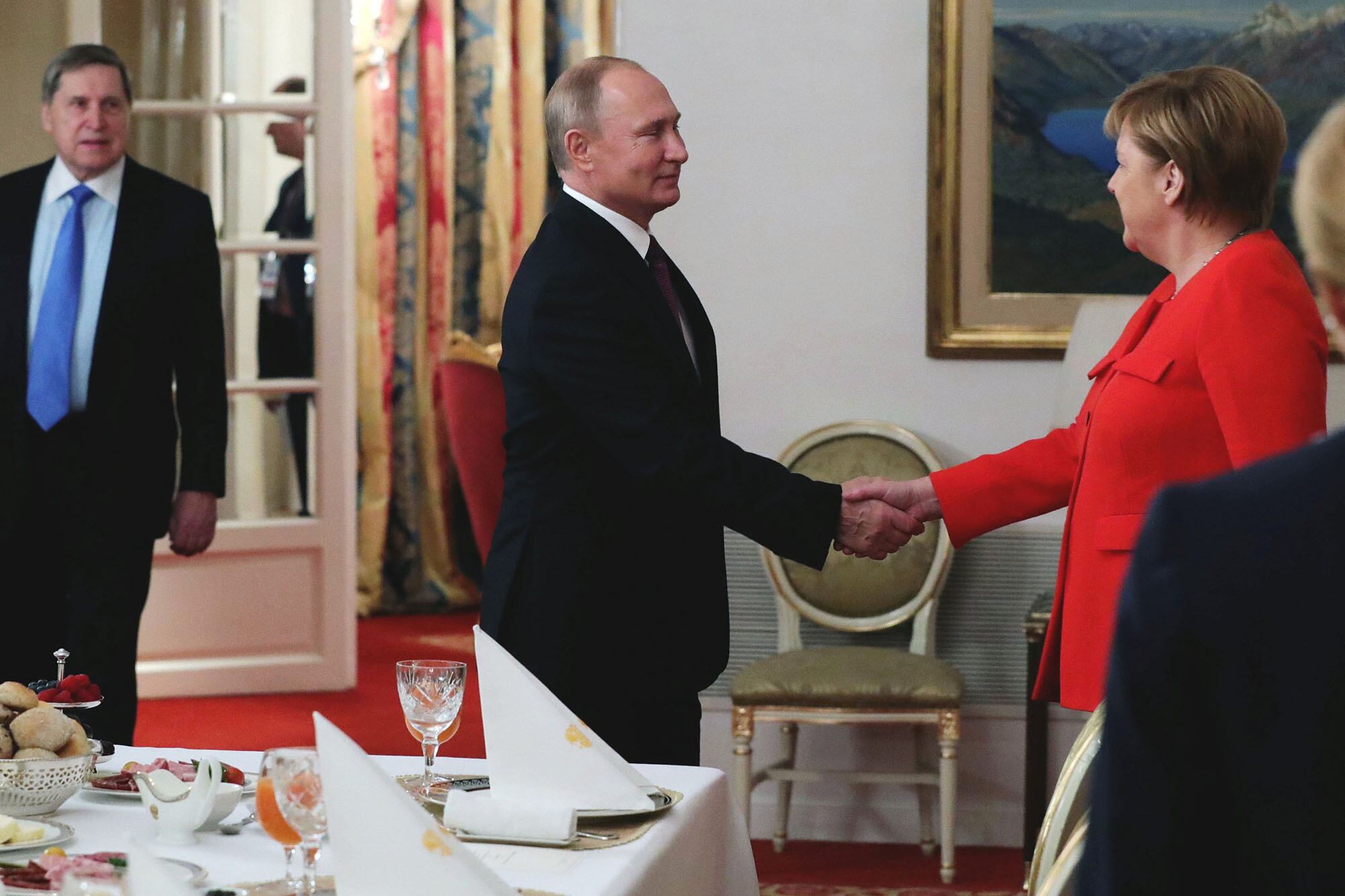 El apretón de manos de Vladímir Putin y Angela Merkel