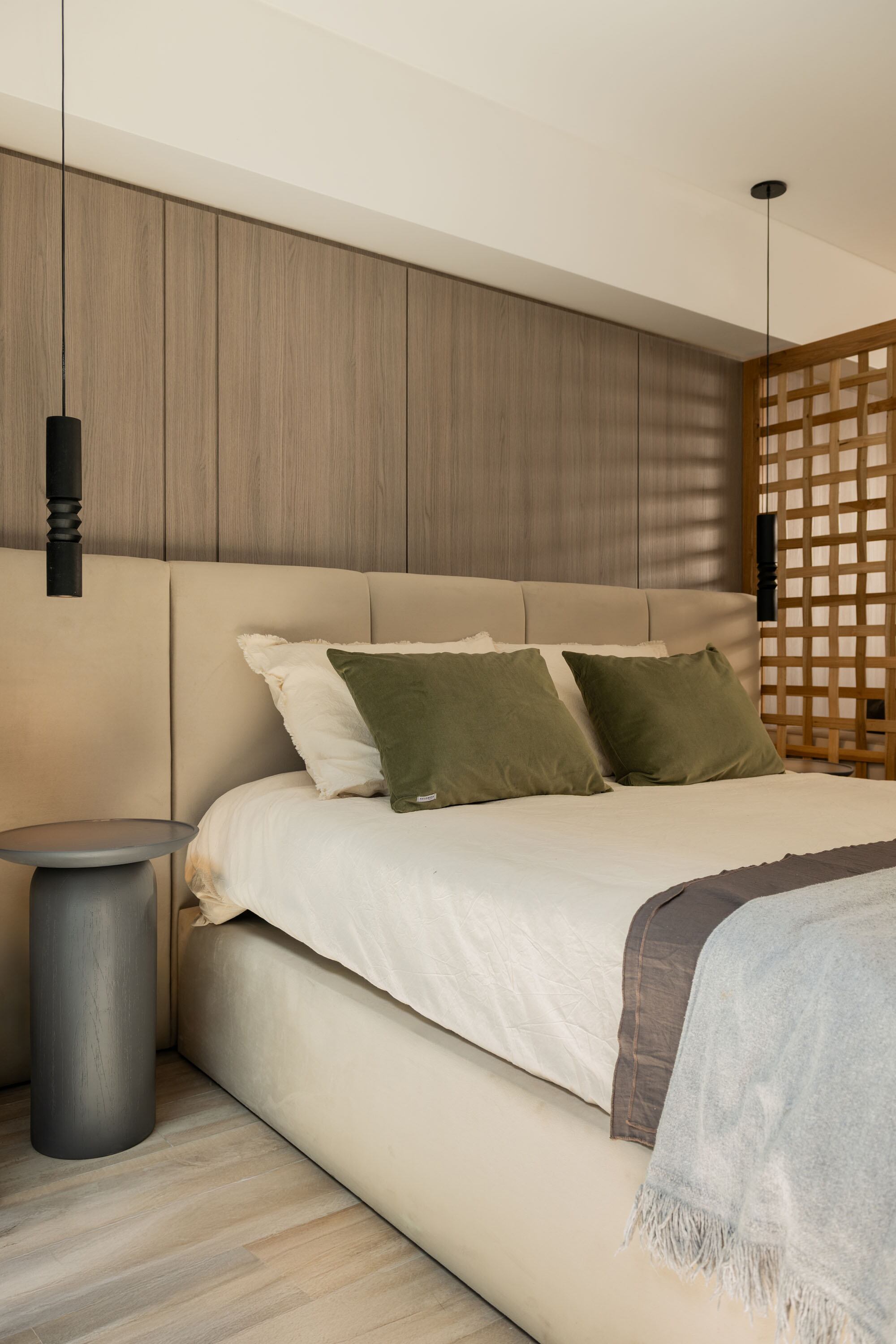 Respaldo y base de cama en pana crudo y mesas de luz en madera paraíso teñida en gris oscuro (Estudio Aldo). Textiles (Philomena Home) y luminarias torneadas (Dimm).