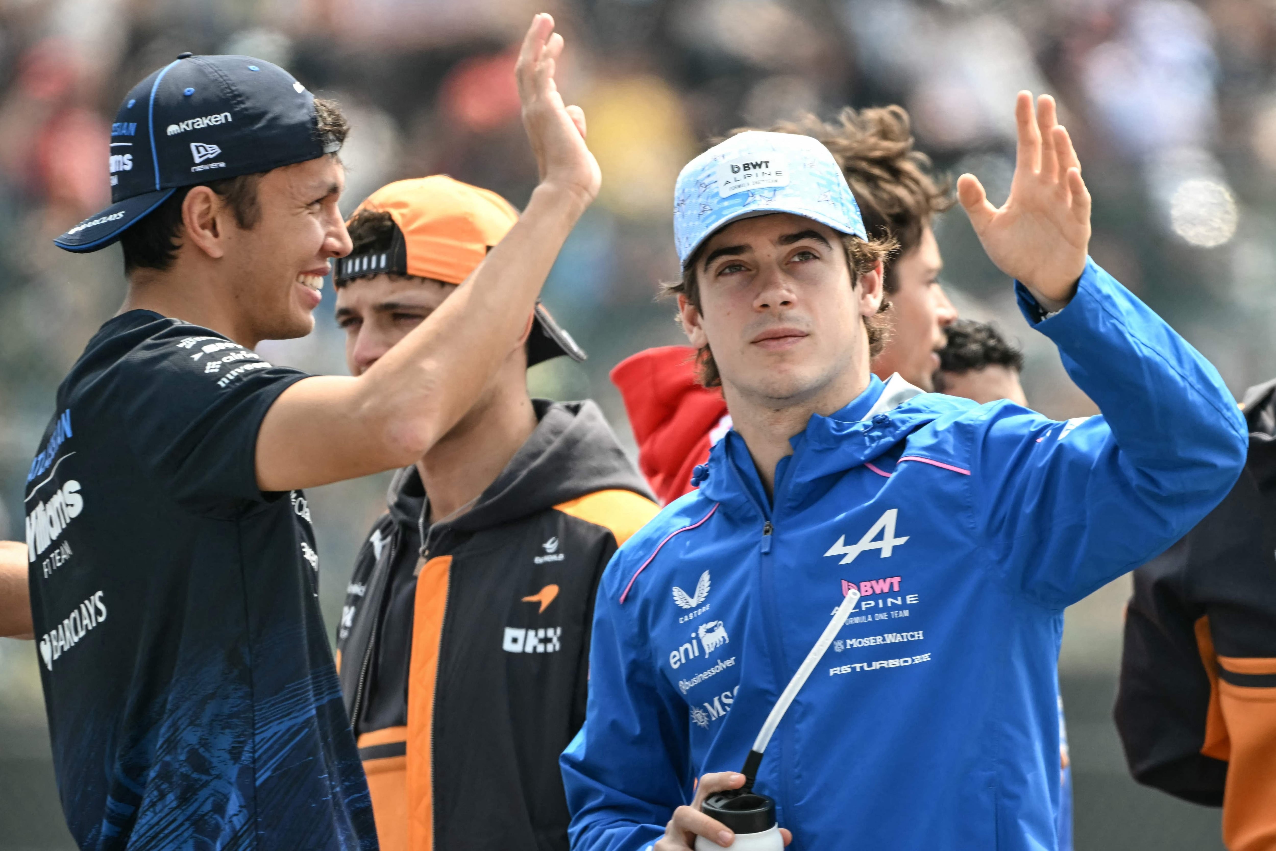 Junto a Alex Albon, compañero en su época de Williams, Franco Colapinto saluda al público en el desfile de pilotos previo a la carrera.