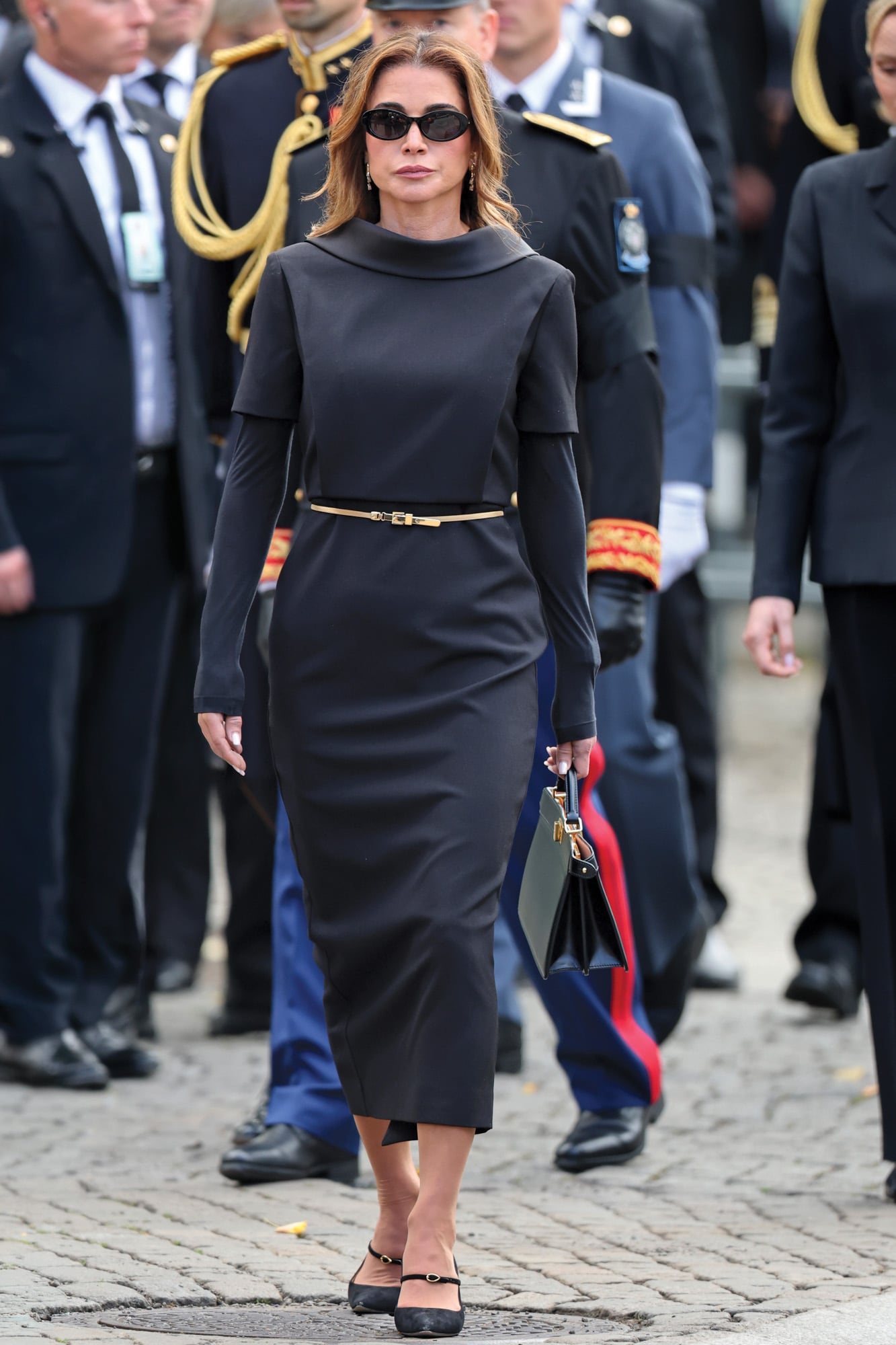 Rania de Jordania llevó un vestido hecho a medida con cuello de Roland Mouret. Lo acompañó con cartera Fendi, zapatos con hebilla Jennifer Chamandi y anteojos de Saint-Laurent