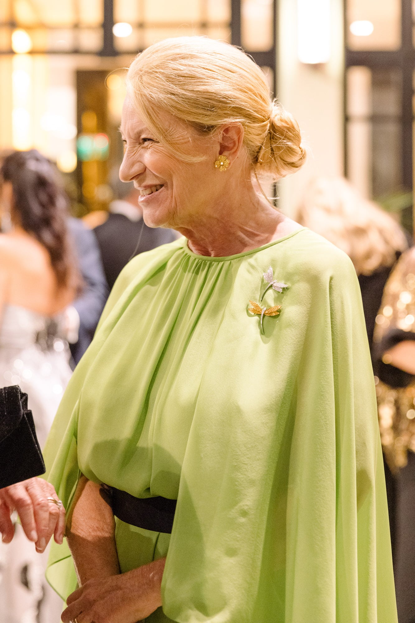María Taquini de Blaquier con vestido con capa incluída y broches de libélulas.