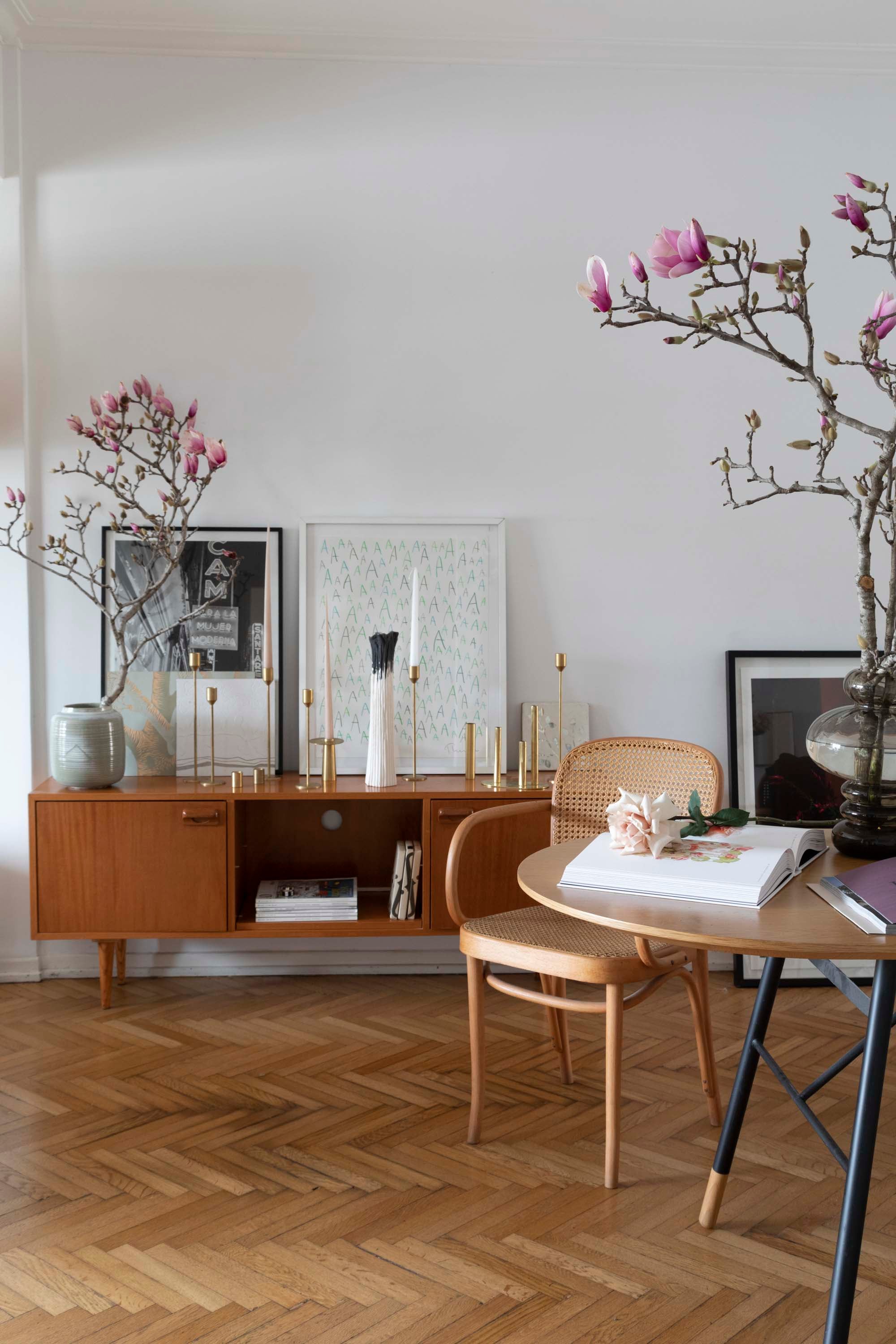 Una cómoda vintage sostiene los candelabros de bronce que Irina Khatsernova mandó a hacer en Argentina. Coronando la puesta, las flores de Magnolia foscata.