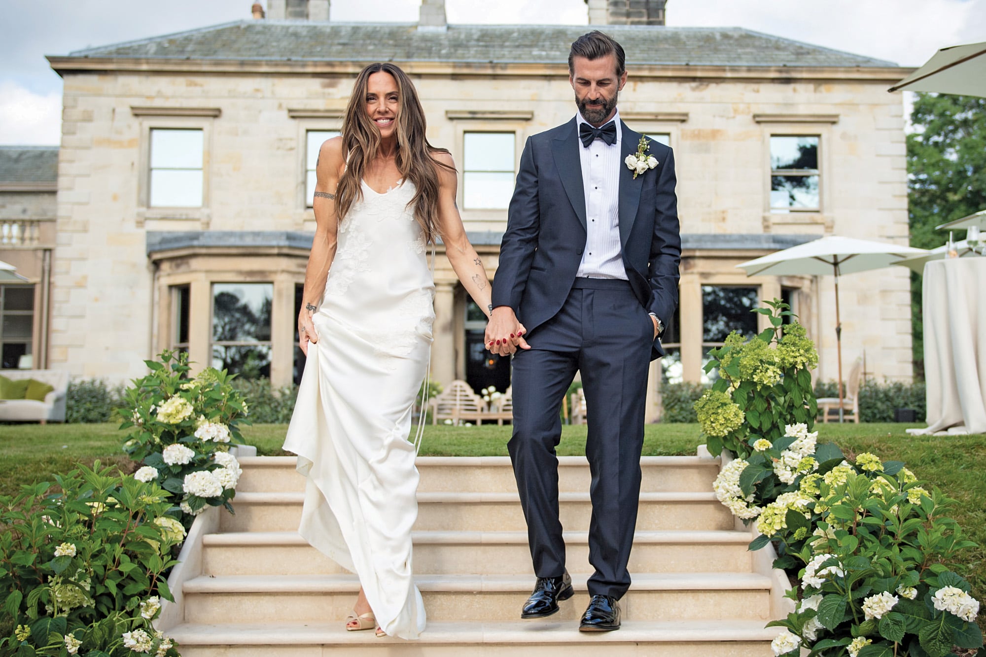 Tras una ceremonia civil en Australia, el país natal del novio, Mel y Chris celebraron una íntima boda de verano a orillas de un lago en Cumbria. La cantante deslumbró con un vestido y zapatos de Victoria Beckham, mientras que él lució un traje de Zegna