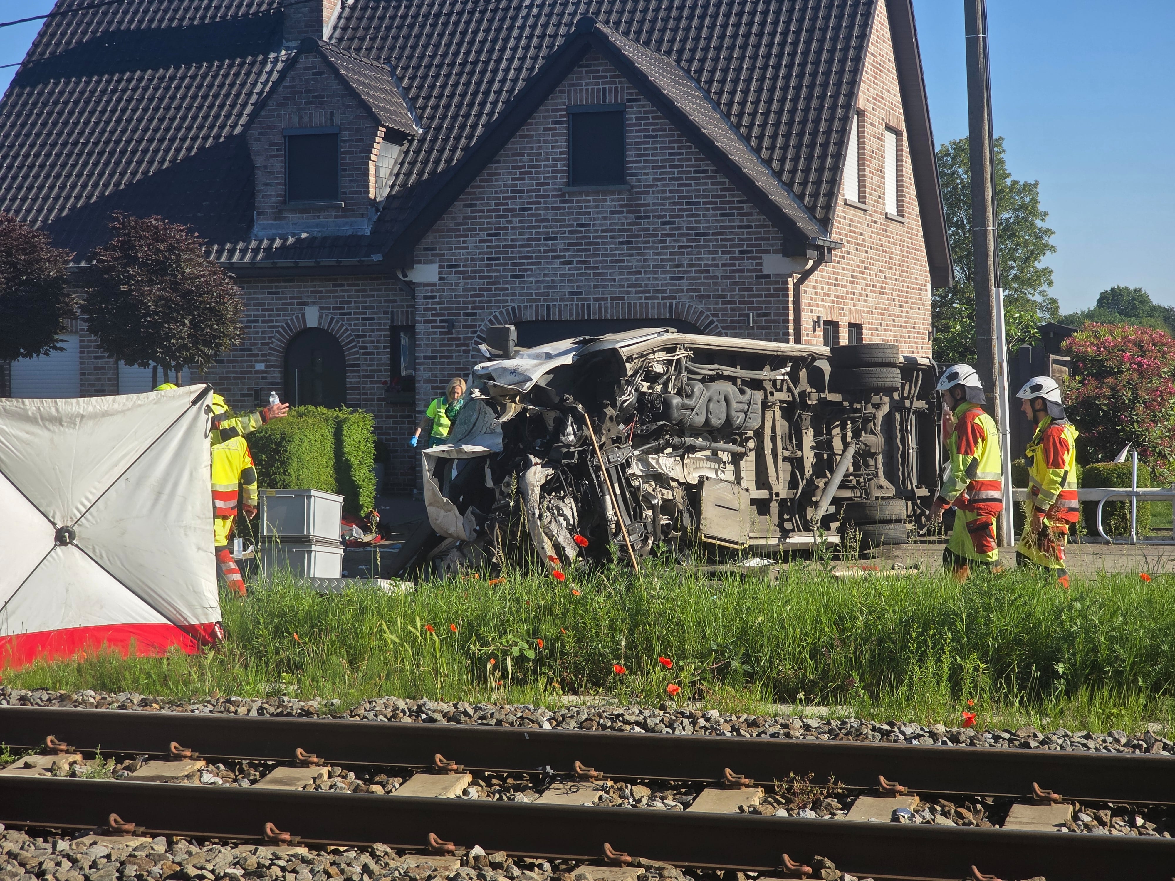 Rescatistas en el lugar de un choque entre un tren y un vehículo en Buggenhout,Bélgica, el martes 26 de mayo de 2026. (AP Foto/Koen Baten)