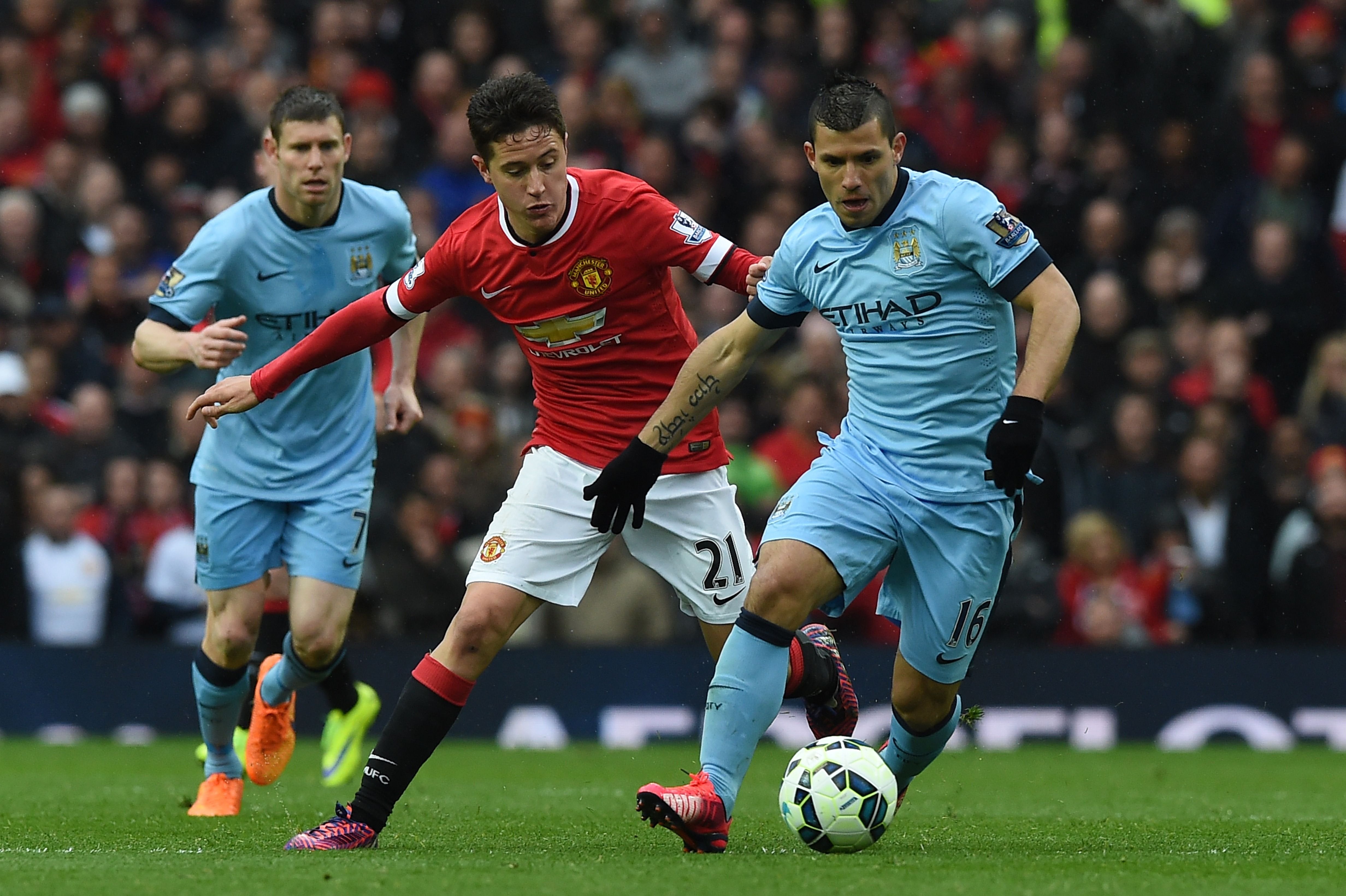 Ander Herrera, con la camiseta de Manchester United, persigue al Kun Agüero, en el clásico de la ciudad