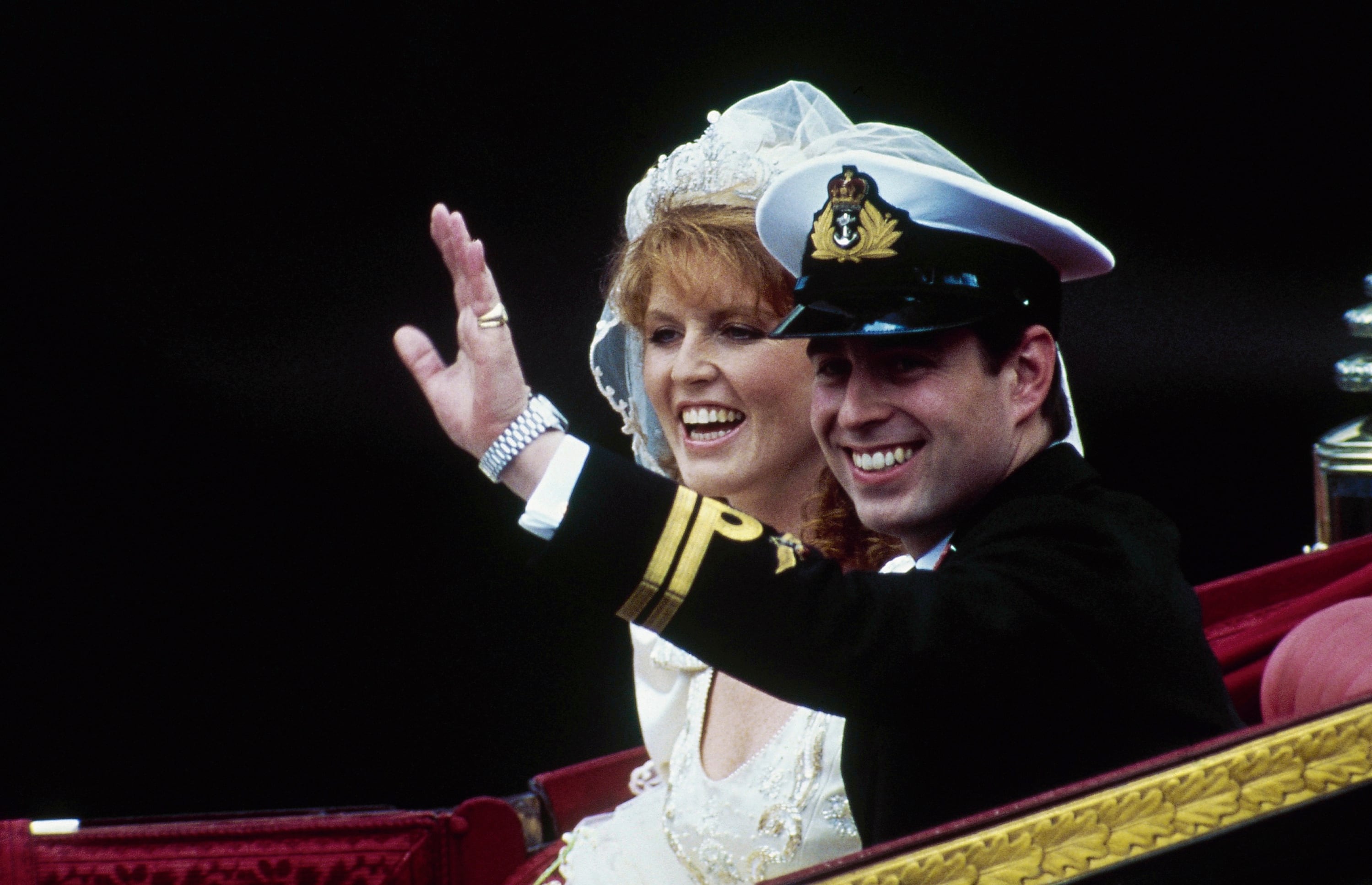 ARCHIVO - El príncipe británico Andrés, junto con su esposa Sarah, saluda desde su carruaje tirado por caballos al salir de la Abadía de Westminster tras su boda en Londres, el 23 de julio de 1986. (Foto AP/Dave Caulkin, Archivo)