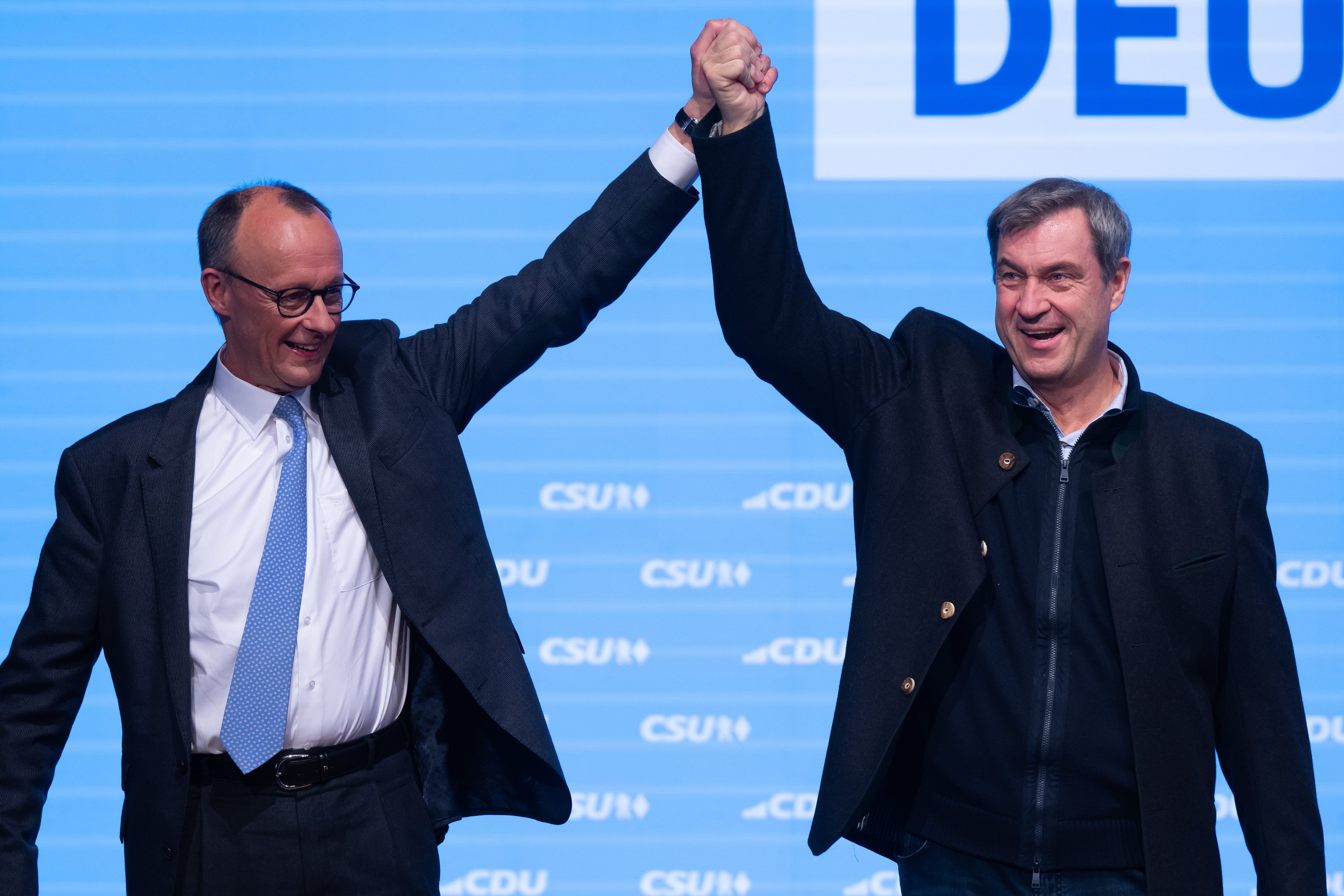 22 de febrero de 2025, Baviera, Múnich: Friedrich Merz, presidente y principal candidato de la Unión Demócrata Cristiana (CDU), y Markus Soeder (R), ministro presidente de Baviera y presidente de la Unión Social Cristiana, suben al escenario en la campaña electoral conjunta del CSU y la CDU en Múnich