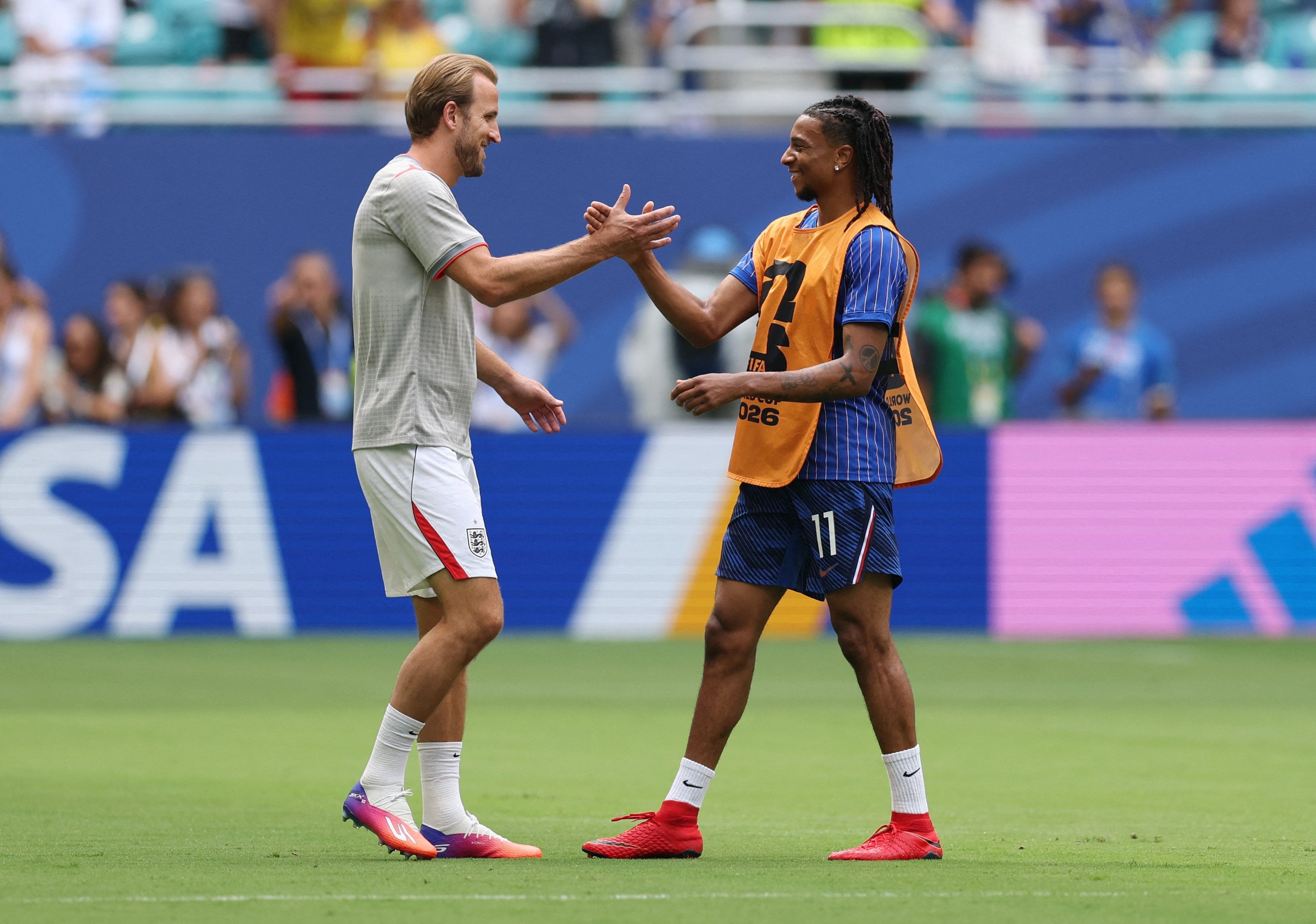 Harry Kane se saluda con Michael Olise, compañeros en Bayern Munich