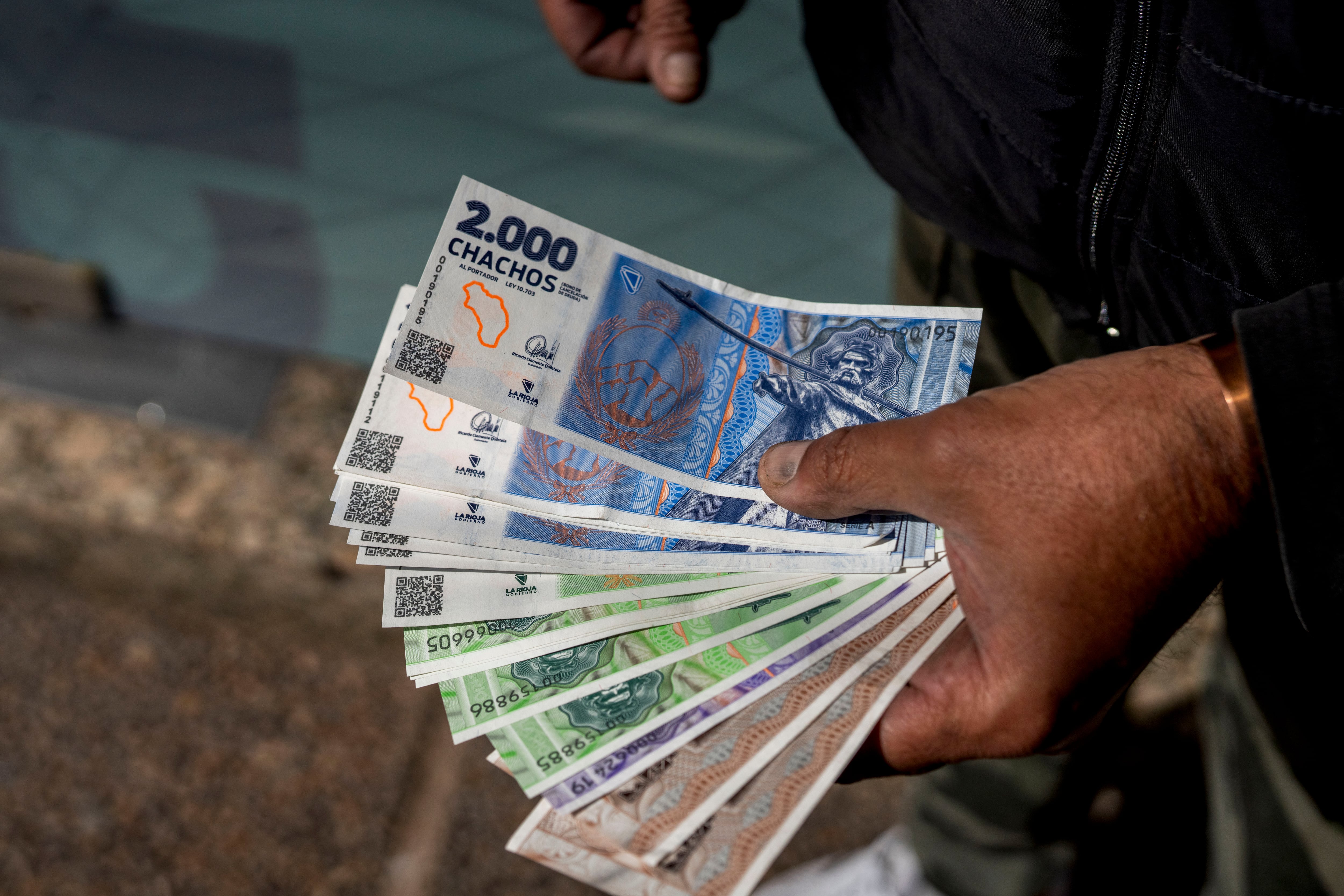 Un vendedor muestra billetes de