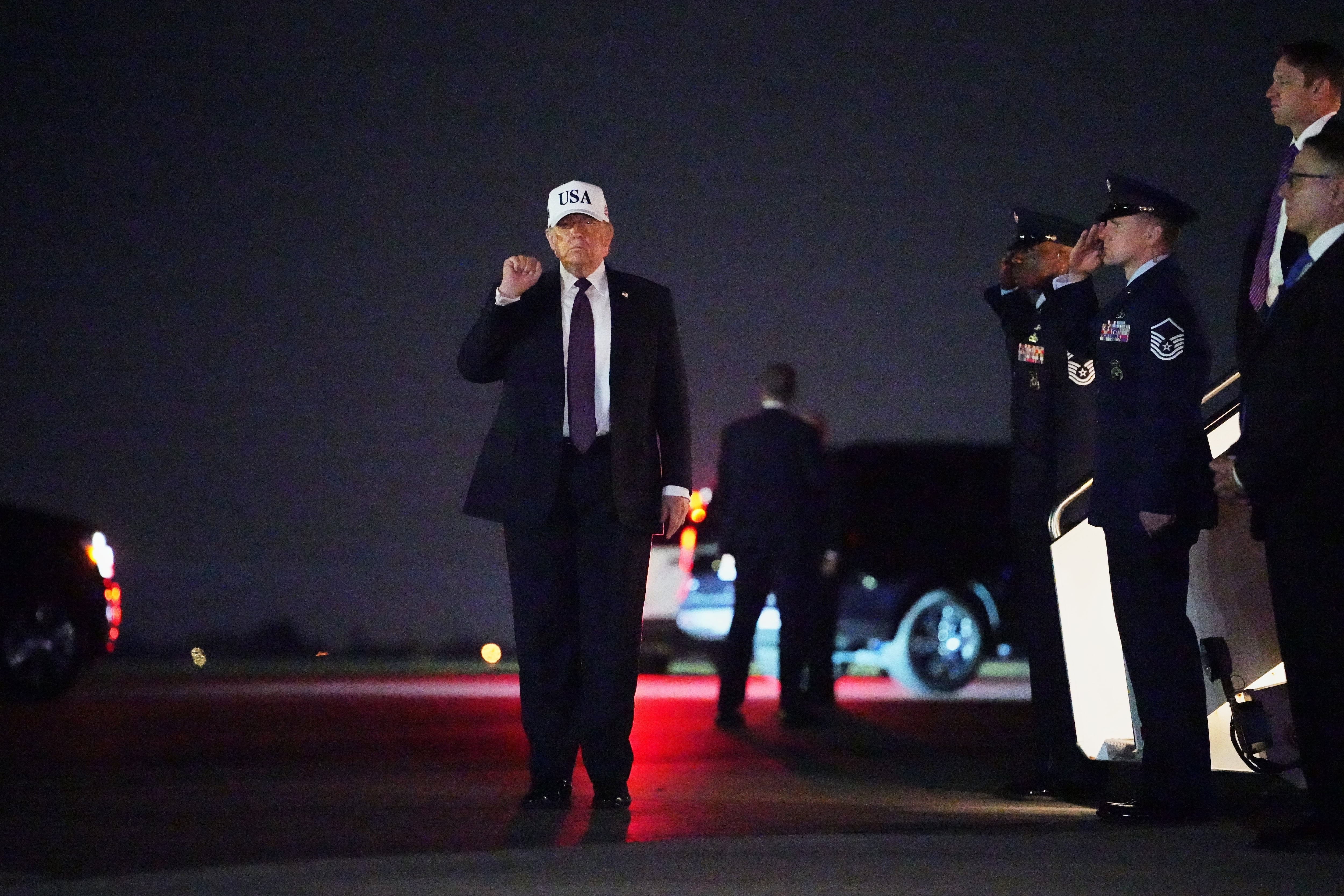 El presidente Donald Trump levanta el puño tras desembarcar del Air Force One en el Aeropuerto Internacional de Palm Beach, en Florida, el 27 de febrero de 2026.