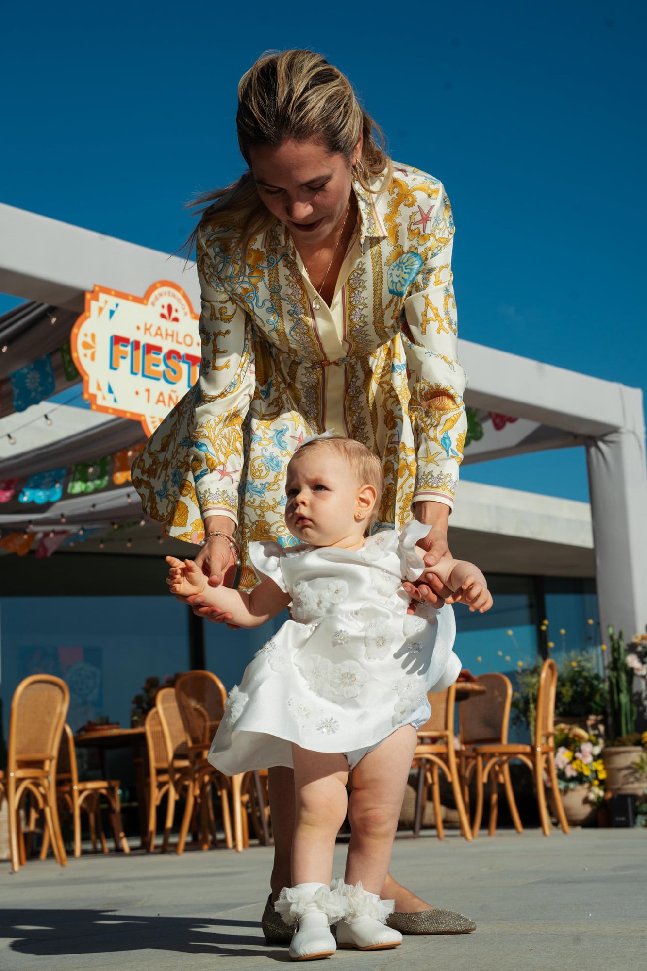 Elina, que lució un vestido Versace, ayuda a su hija a dar sus primeros pasos