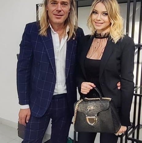 Oscar posa con la periodista Joanna Lo y una de las carteras de su marca GaraVani