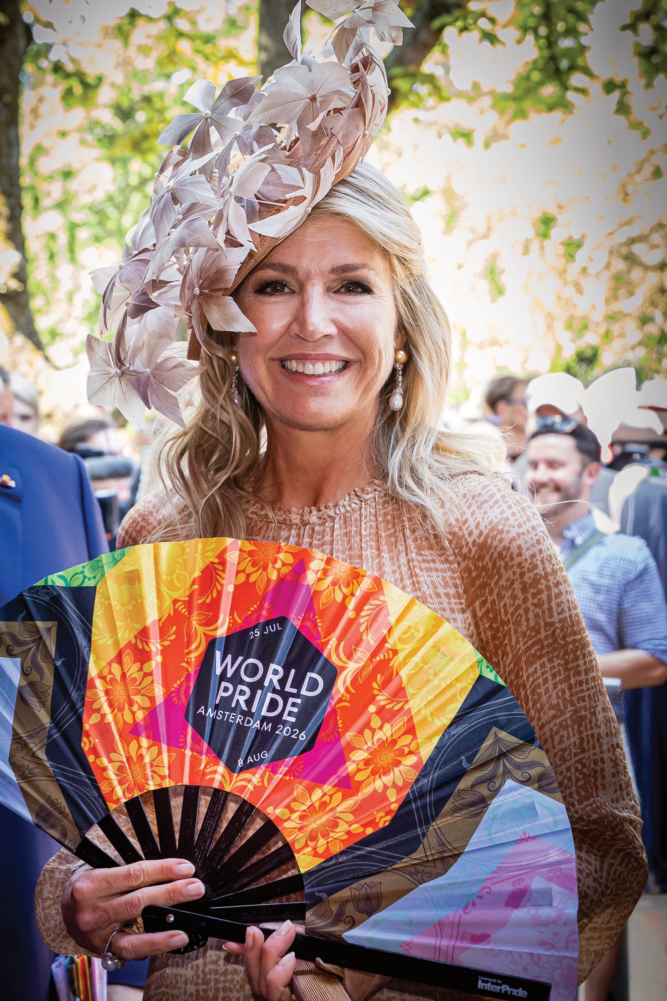 La Reina eligió un vestido semitransparente de alta costura de Natan, de manga larga, cuello a la base, cintura marcada y un original estampado de cuadros, que acompañó con un tocado XXL confeccionado con decenas de hojas de laurel en dorado, de la firma neerlandesa Berry Rutjes