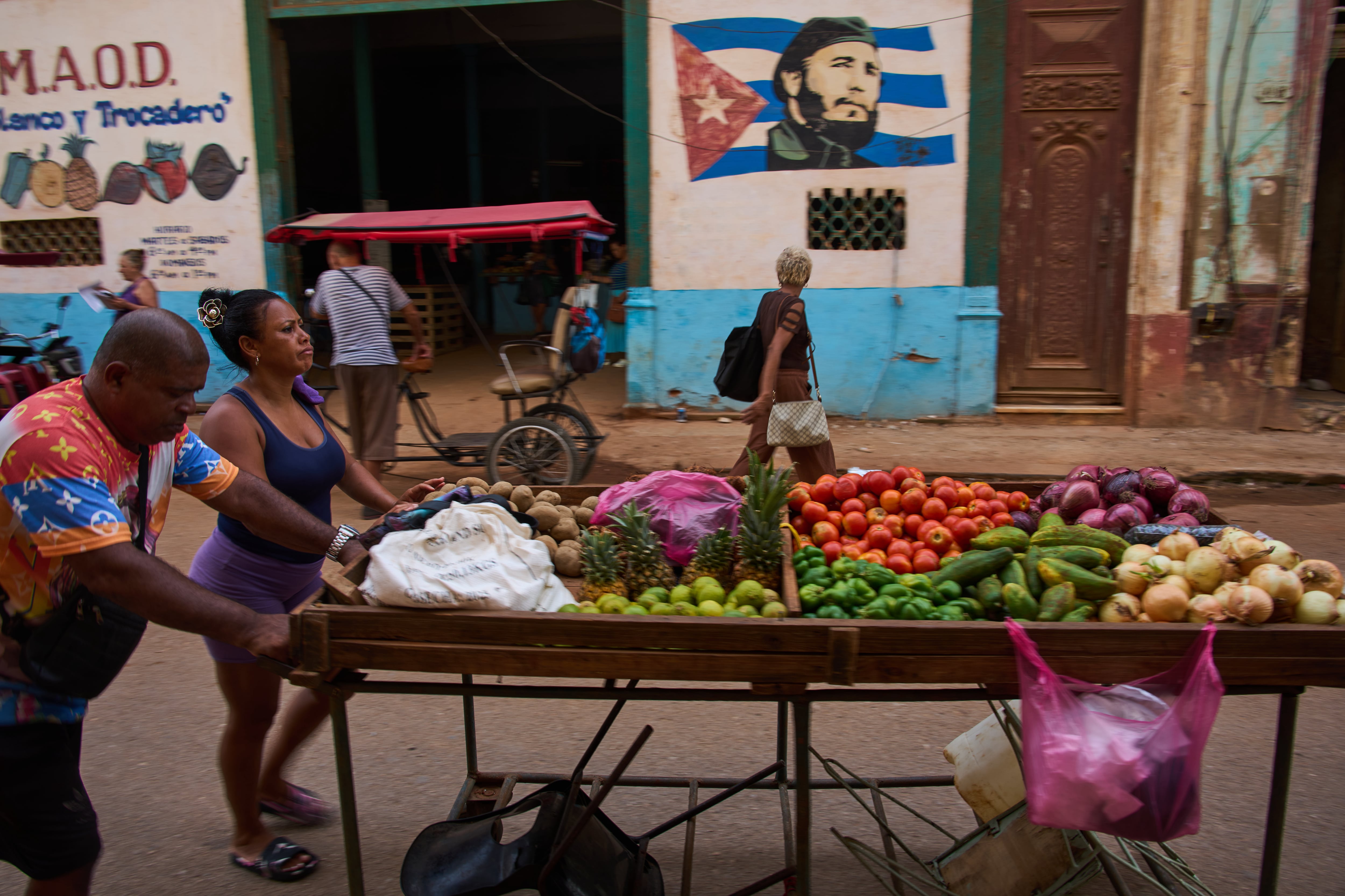 Vendedores ambulantes empujan su carrito de verduras frente a un mural de Fidel Castro en La Habana, Cuba, el miércoles 12 de agosto de 2026. (Foto AP/Ramón Espinosa)