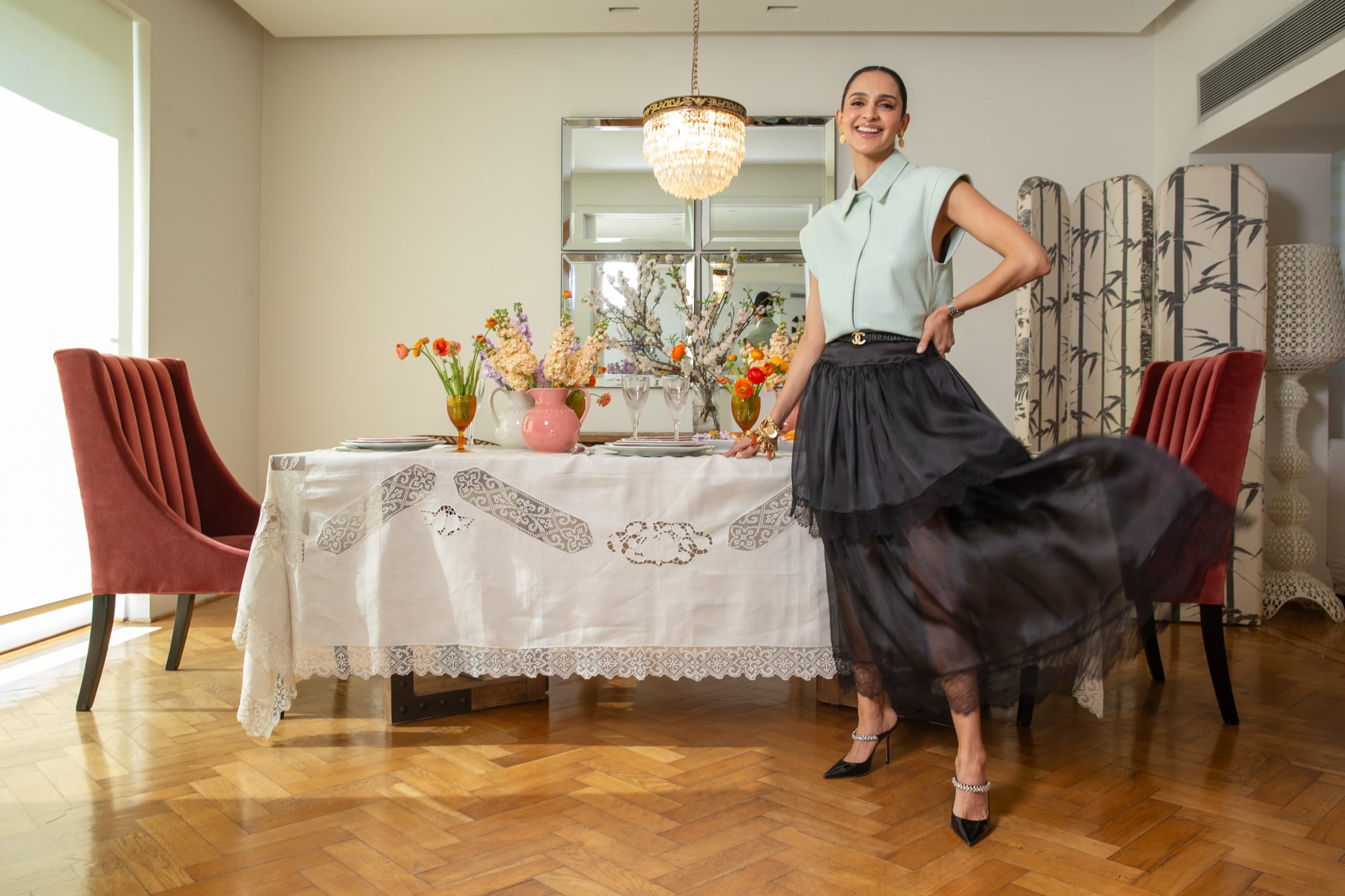 Atenas Hernández posa espléndida en el comedor de su hogar en Recoleta. Lleva un top de cuero de Doma diseñado por ella, falda semitransparente rematada con encaje de Chanel, firma de la que es embajadora, y altísimos tacos Jimmy Choo.
