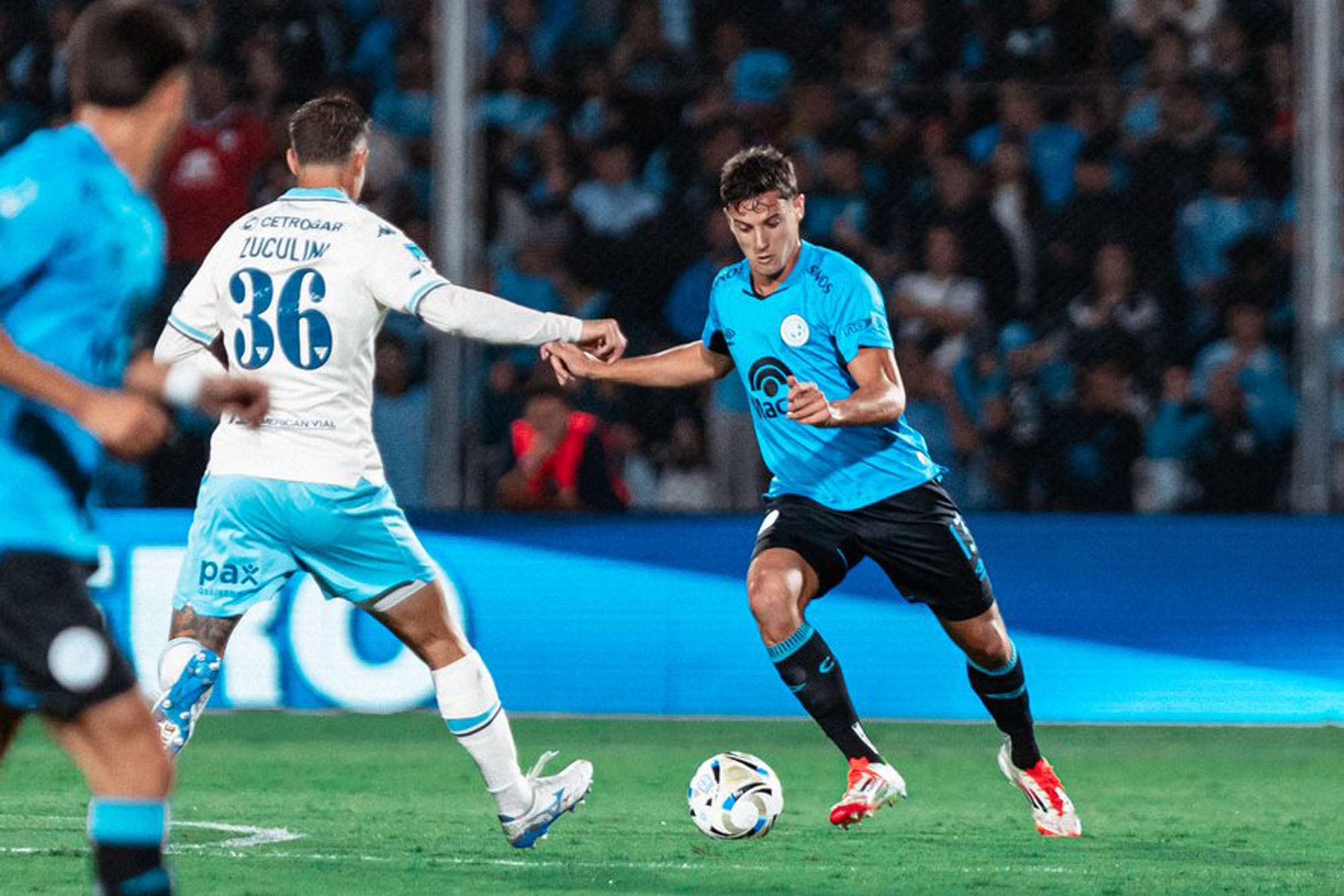 Álvaro Ocampo va a pegarle a la pelota ante una llegada de Bruno Zuculini para marcar.