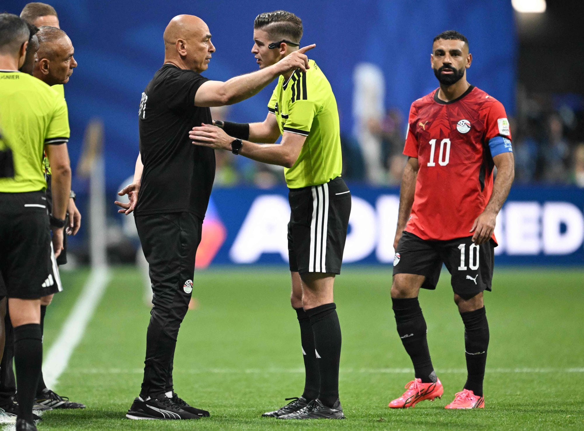 El seleccionador egipcio Hossam Hassan reclama ante el árbitro francés Francois Letexier, ante la mirada del capitán Mohamed Salah; el DT alentó la polémica al calificar que se trató de
