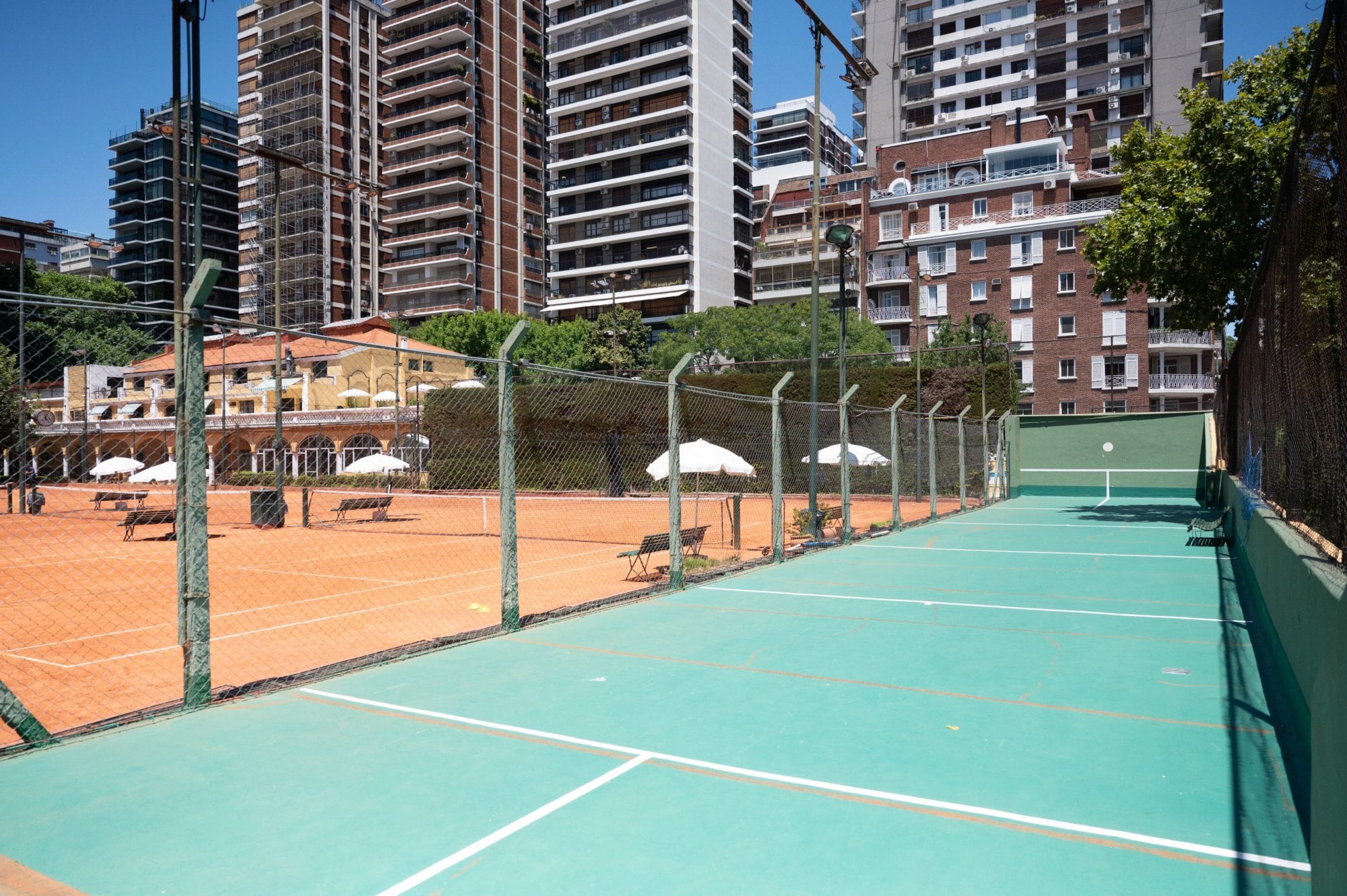 La cancha de tenis junto a una cancha de paleta