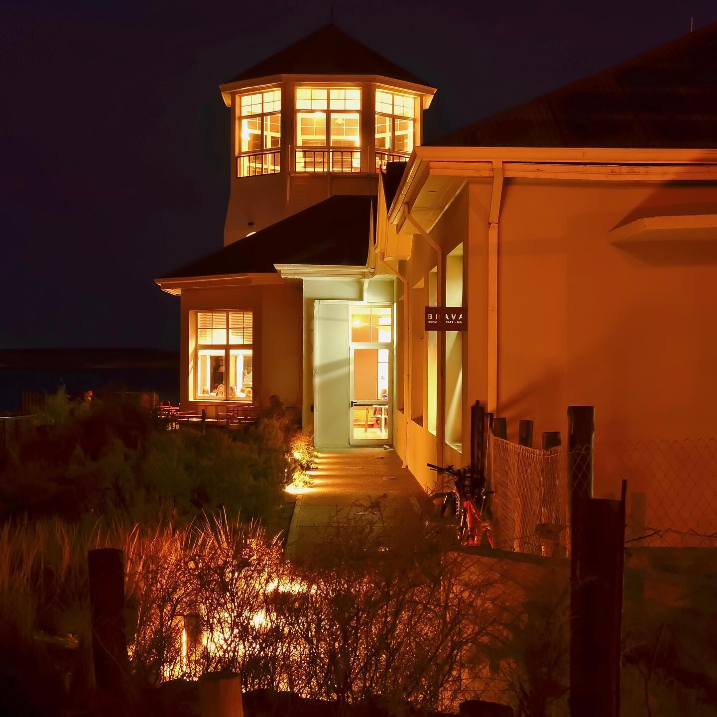 Una imagen nocturna del Ecocentro de Puerto Madryn y de su café, Brava