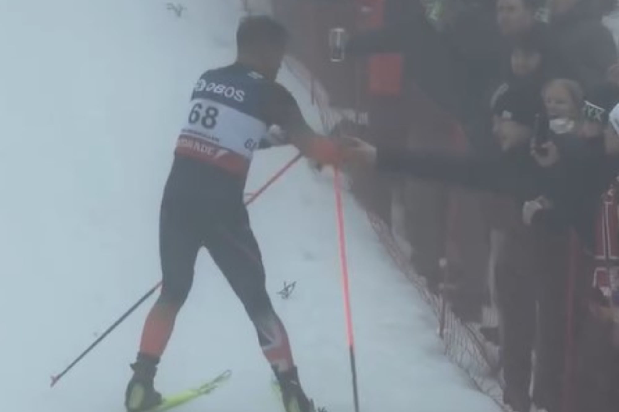 El momento en donde el esquiador recibe la bebida alcohólica en plena carrera