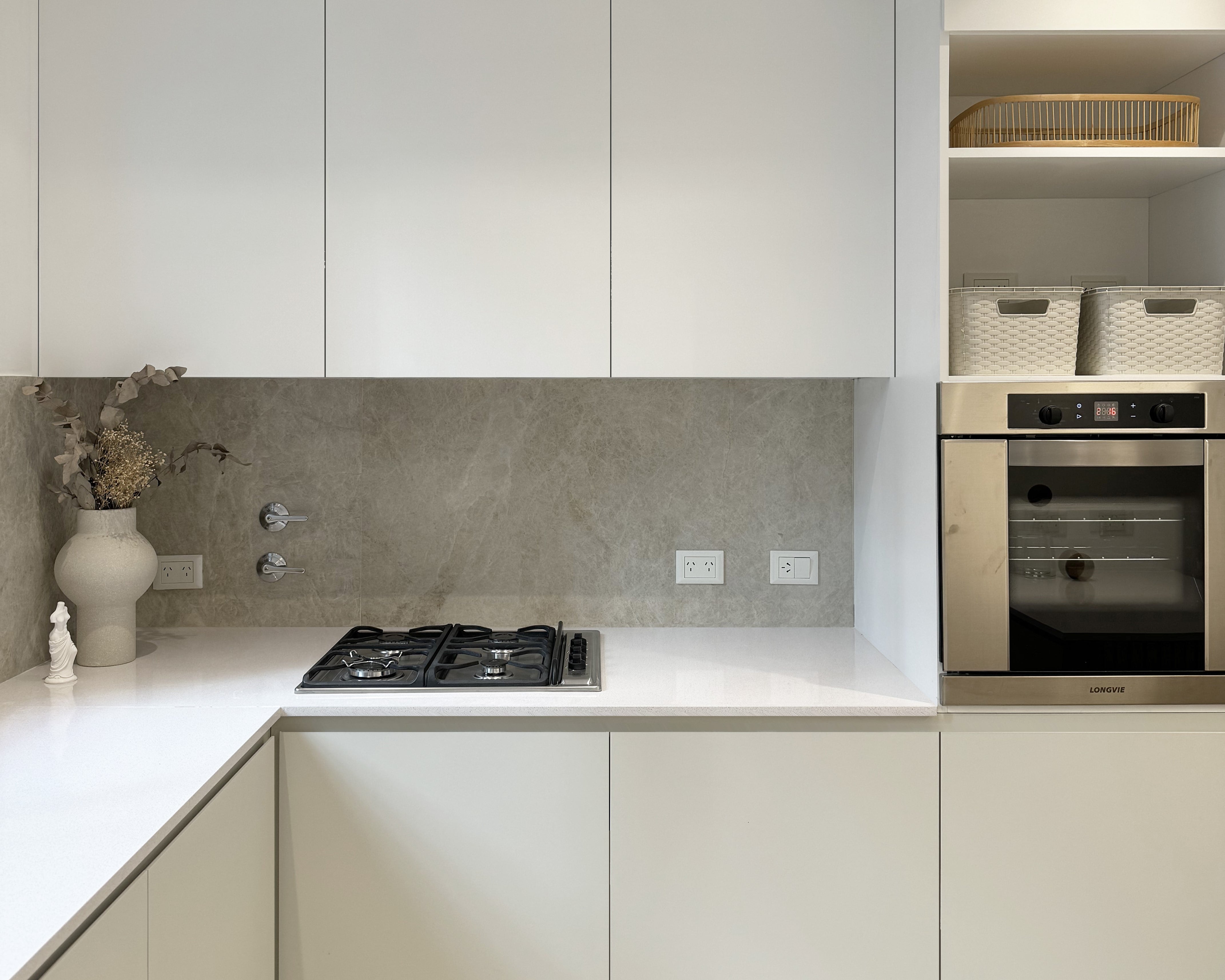 Mesada, Silestone Blanco Norte (Canteras del Mundo por Marmolería Cervaiole). Muebles de cocina (diseñados y ejecutados por el estudio, el bajo mesada en el tono Agreeable Gray de Sherwin Williams) y revestimiento en alzada (Portobello Moonlight Sand Natural, SBG). Bandeja (Sol Palou Deco), florero (Orilla Home), escultura Venus de Milo (Roma Doma).