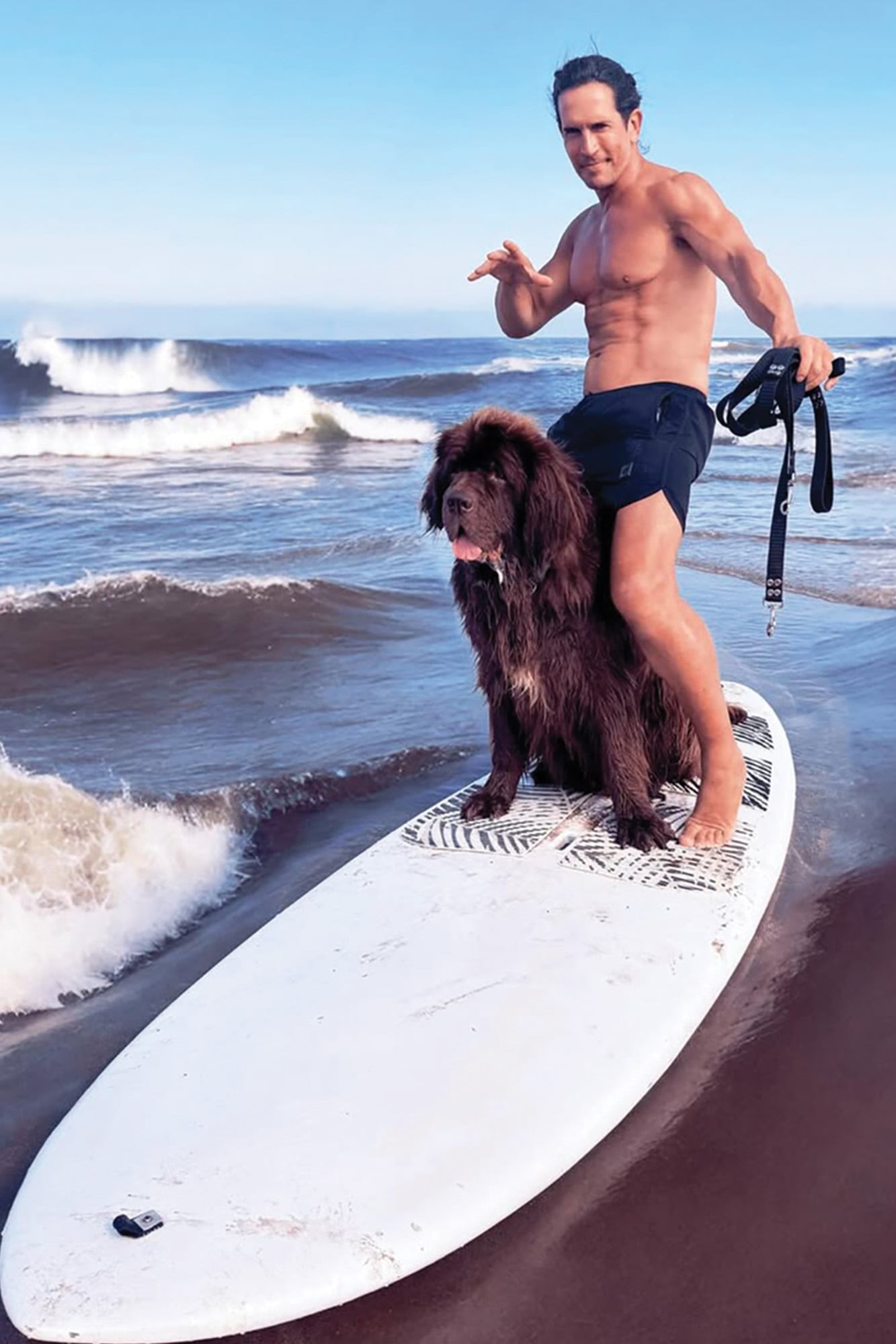 Diego posa con uno de sus perros a orillas del mar