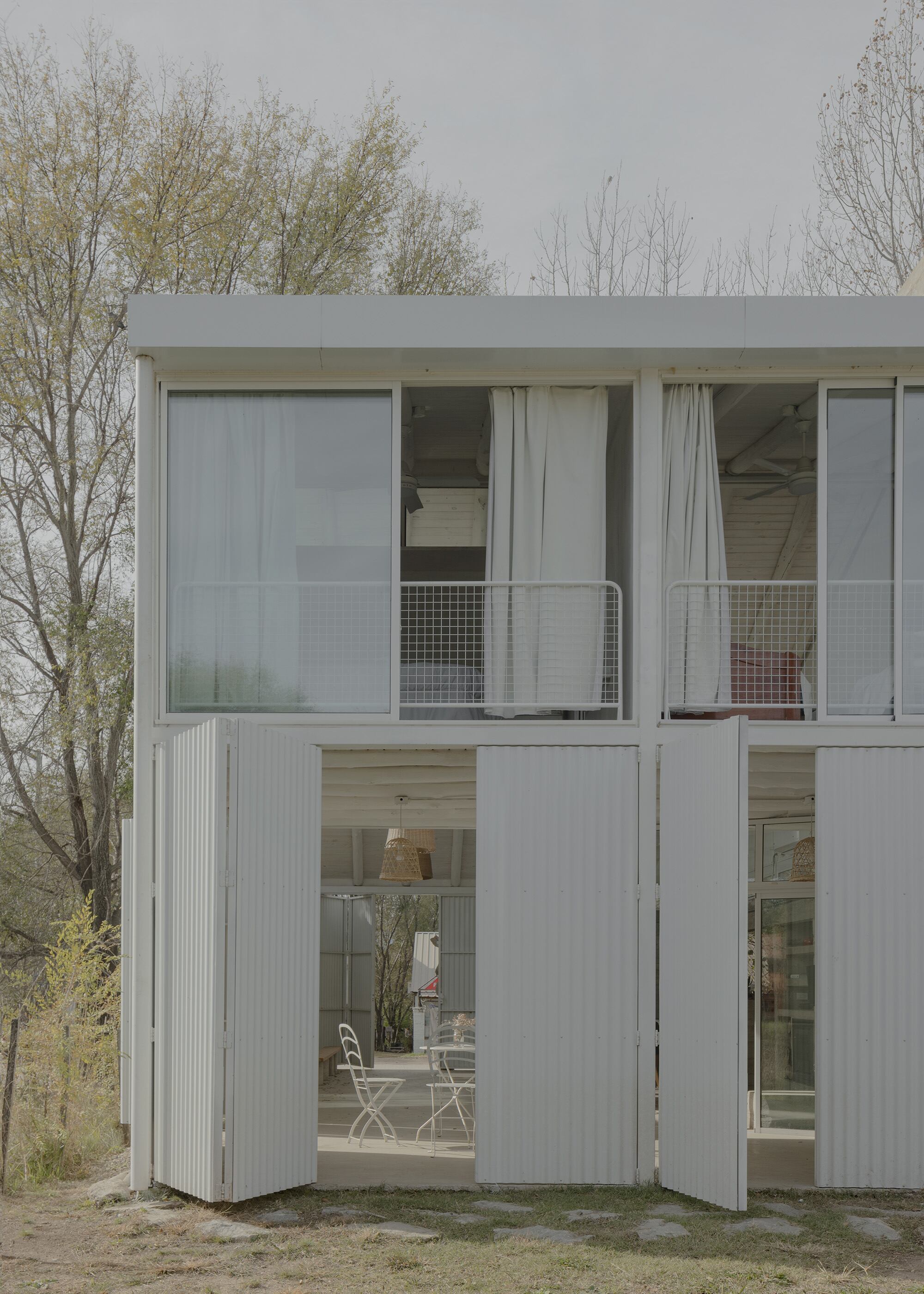 Los dormitorios de la planta alta son iguales y se abren al patio con puertas-ventanas que definen la fachada vidriada, solo interrumpida por una baranda metálica sencilla que se colocó por dentro.