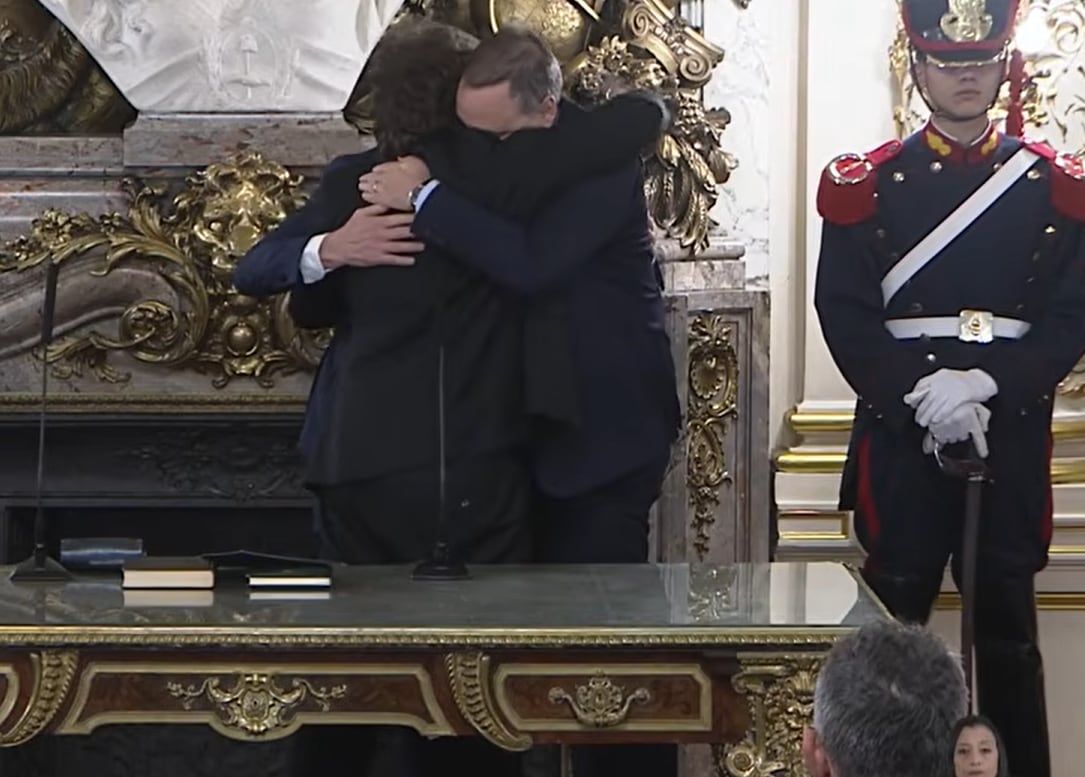 El abrazo de despedida a Adorni, con Santilli en el medio