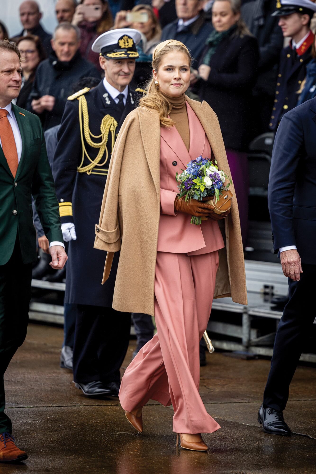 La princesa eligió un traje rosa empolvado de Max Mara, de blazer de doble botonadura y pantalón ancho pinzado, que llevó hace unos meses junto a su madre en un evento solidario en Atenas. En esta ocasión, le sumó un suéter de cuello alto y un tapado ¾ marrón de la misma firma. Sumó guantes de gamuza, cartera de mano de Marina Raphael y stilettos a tono.