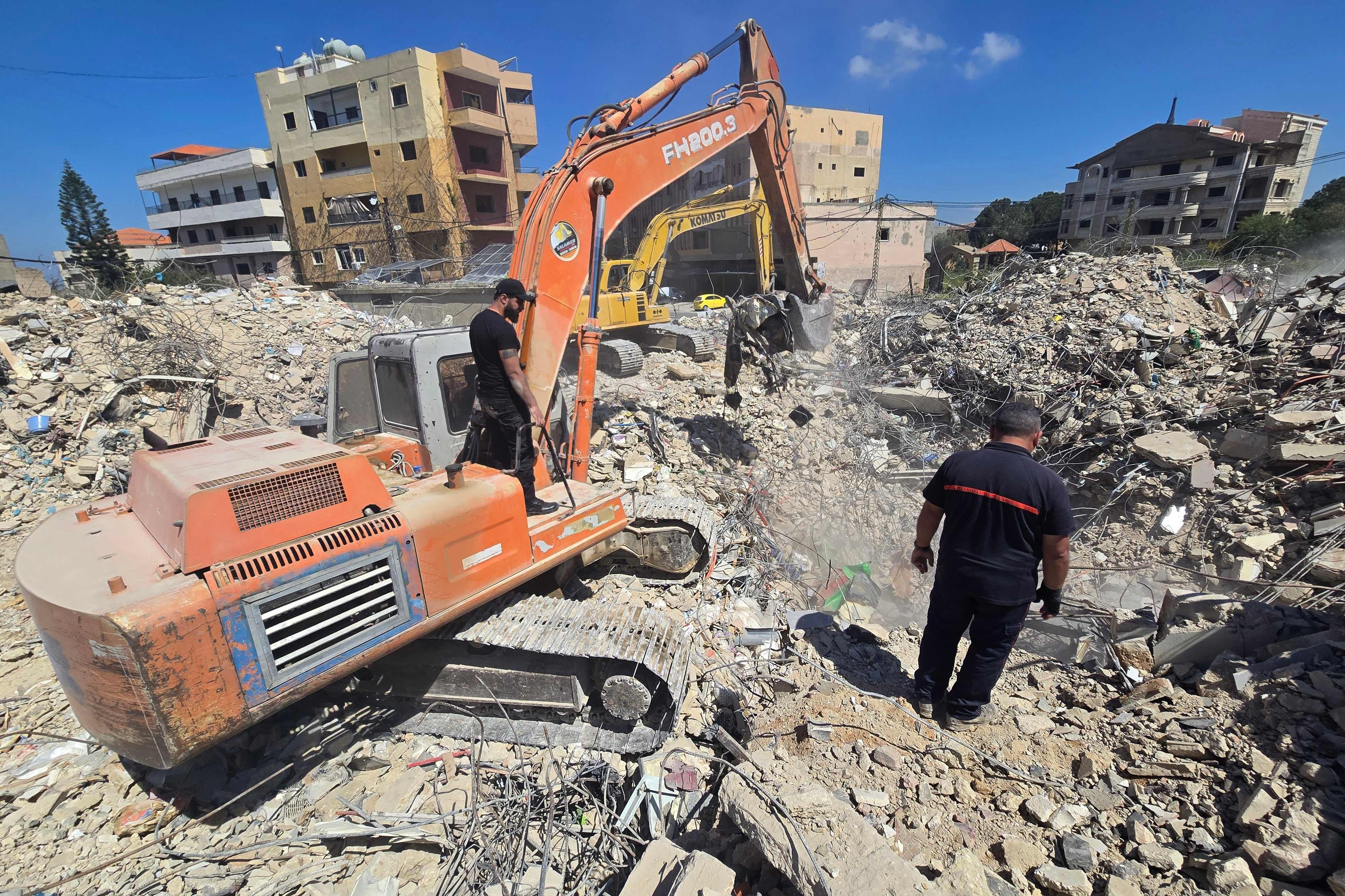 Excavadoras son utilizadas por equipos de rescate que trabajan para retirar los escombros de un edificio previamente alcanzado por el ejército israelí, en la localidad de Hanaouay, en el sur del Líbano