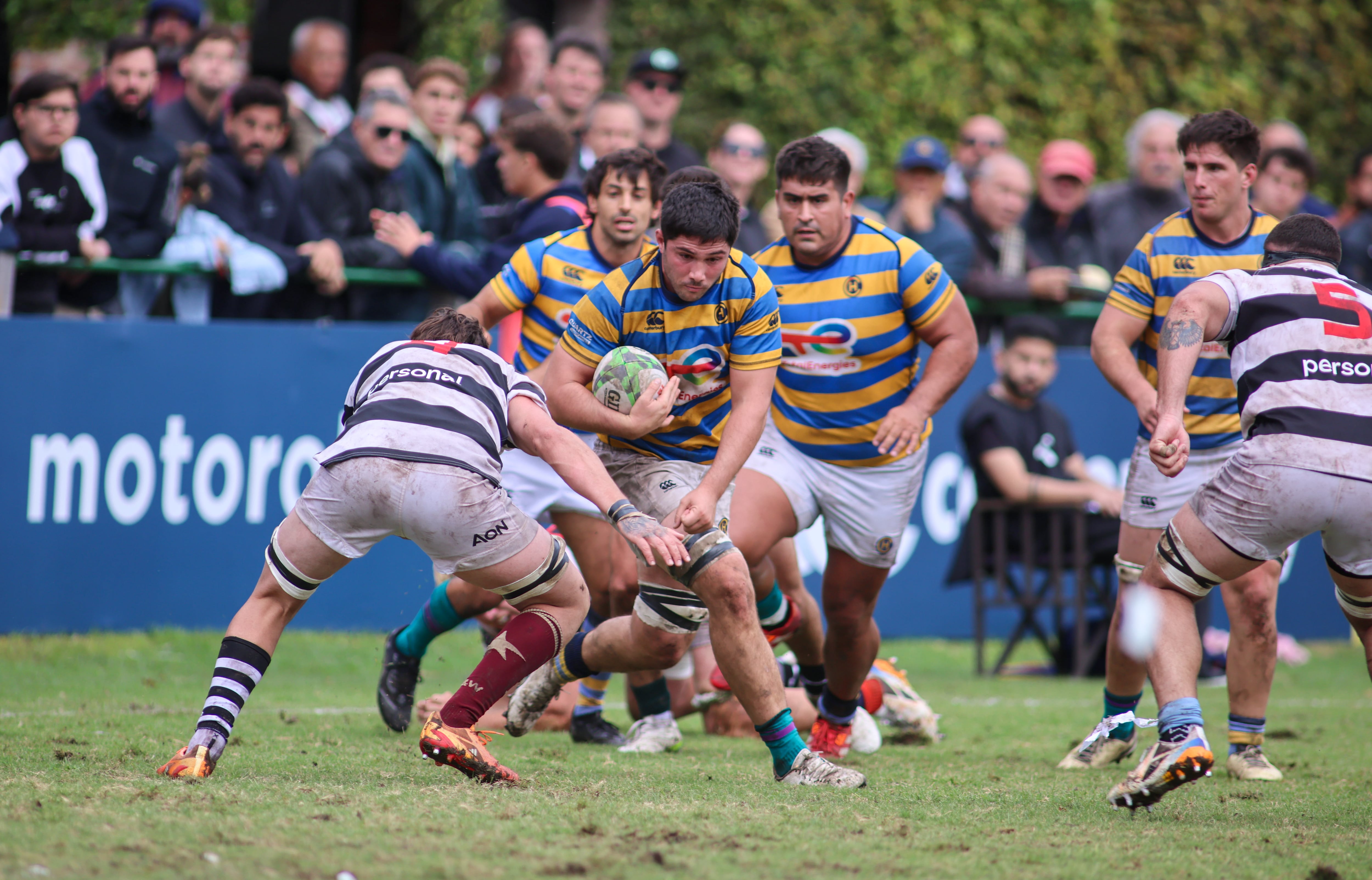 Nicolás Amaya, octavo de Hindú, afronta un tackle de Salvador Ochoa; van en respaldo Nicolás Leiva y, al fondo, Ezcurra.