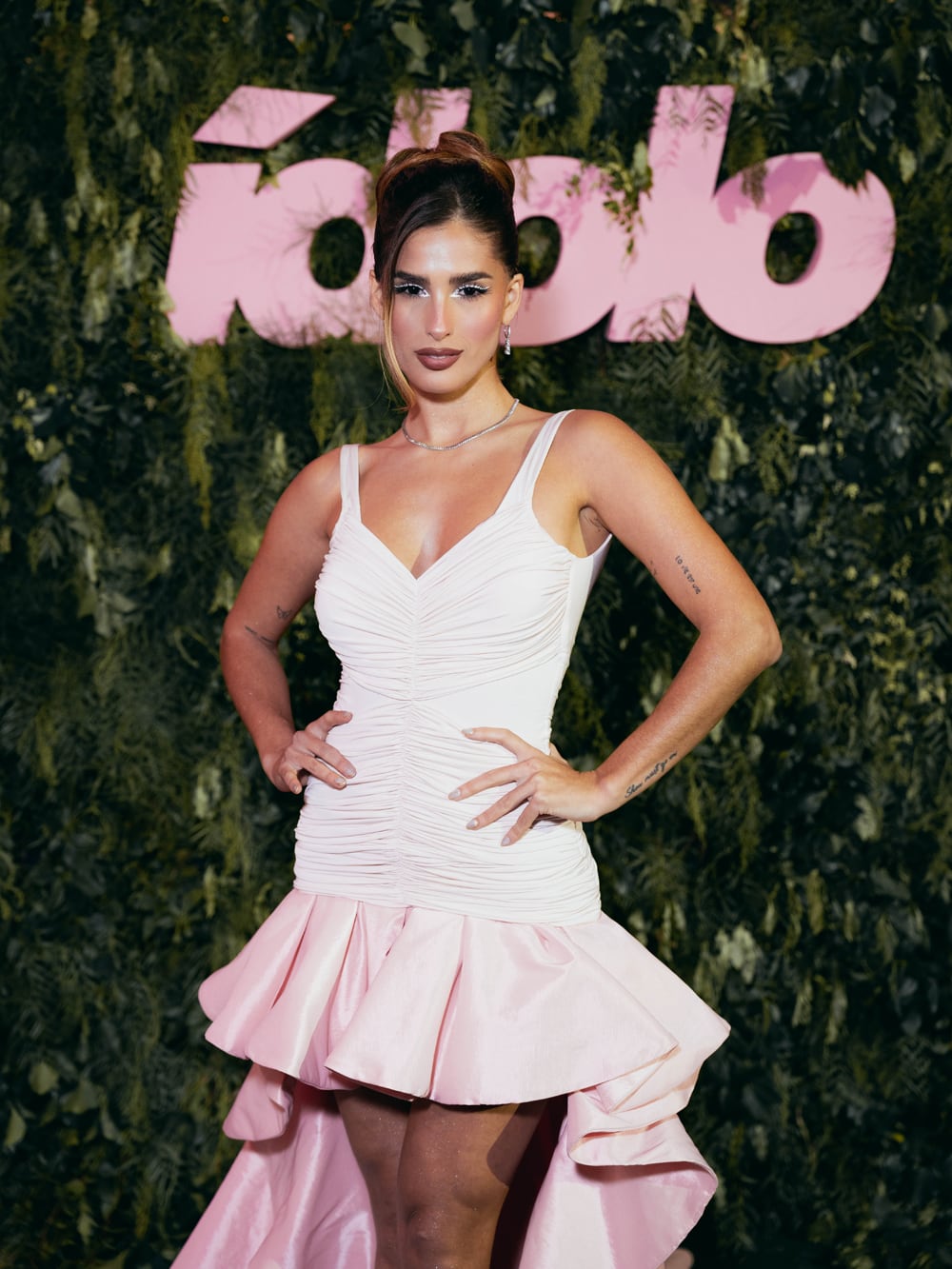 Juli Poggio, tras terminar su tarea en la alfombra verde, cambió su outfit por un vestido corto en blanco y rosa, con escote corazón, dreapeado central, falda con volados y cola