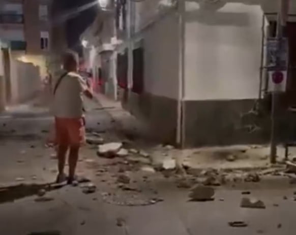 Un transeúnte registra los derrumbes en el centro granadino