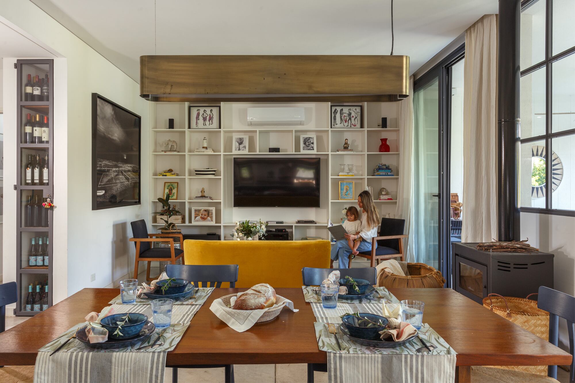 Con diseño de Nicho, biblioteca y sillones producidos por Bull. Foto de José Pereyra Lucena. Sillón ‘Palma’ amarillo (Mesopotamia). Canasto (Fraternidad). Salamandra encargada a medida (Tromen).