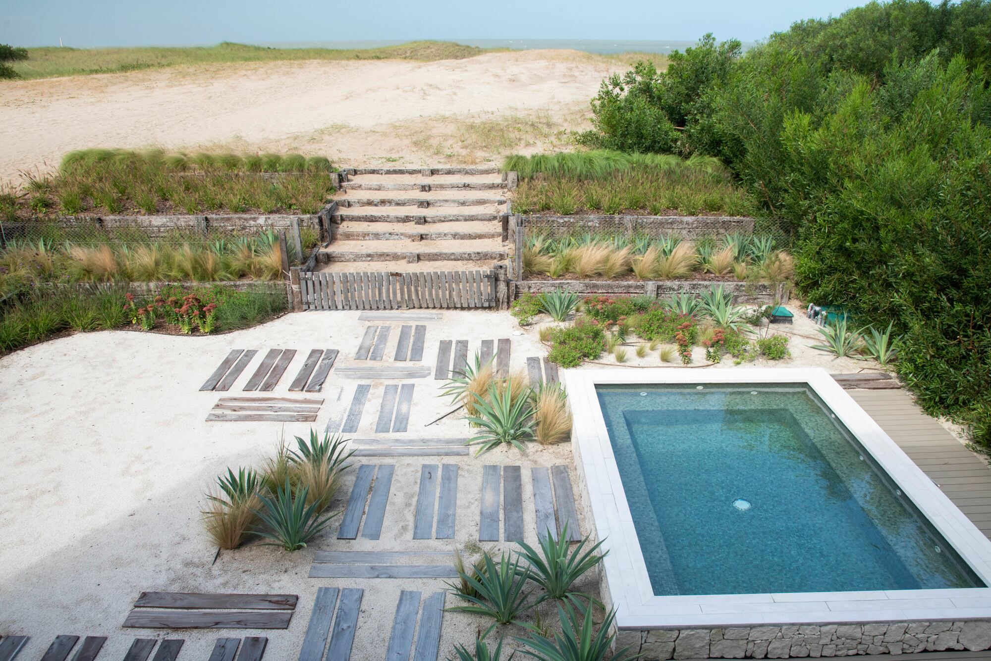 Una escalera conecta lo agreste de la naturaleza con el jardín cercano a la casa