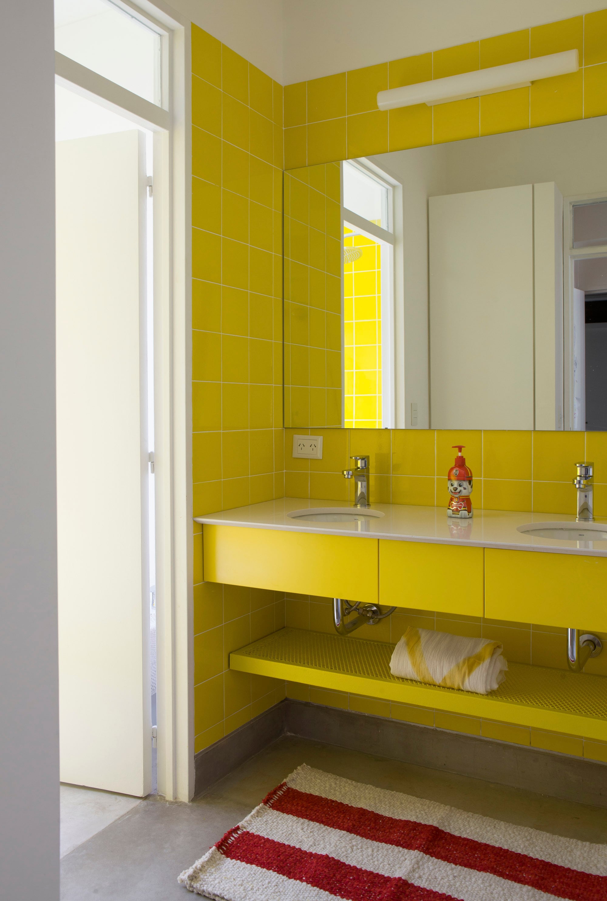 En este antebaño, el color toma toda una pared, y asimismo la mesada y el estante inferior.
