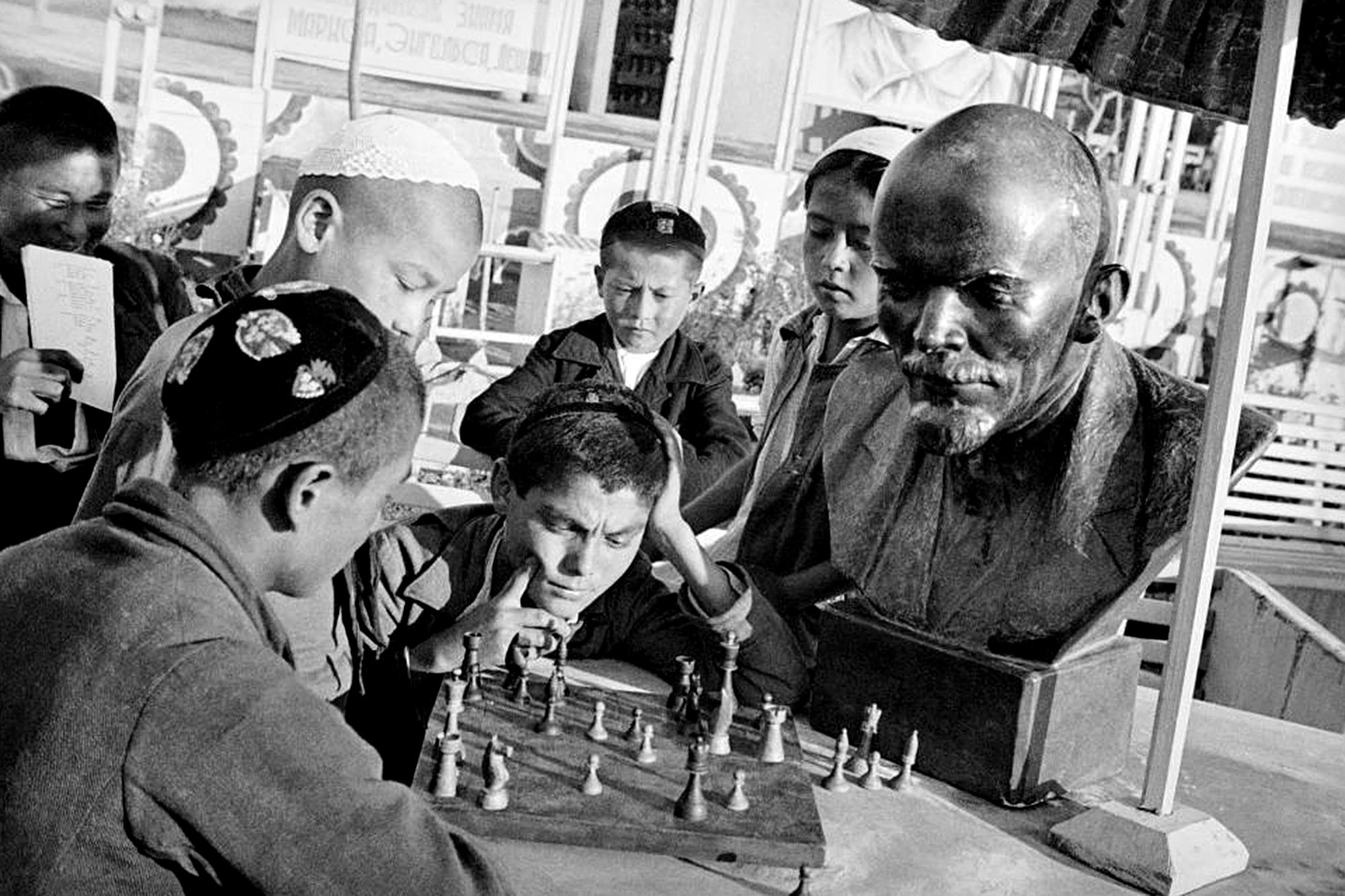 Dos niños juegan al ajedrez bajo la mirada de un busto de Lenin, en la década del 40