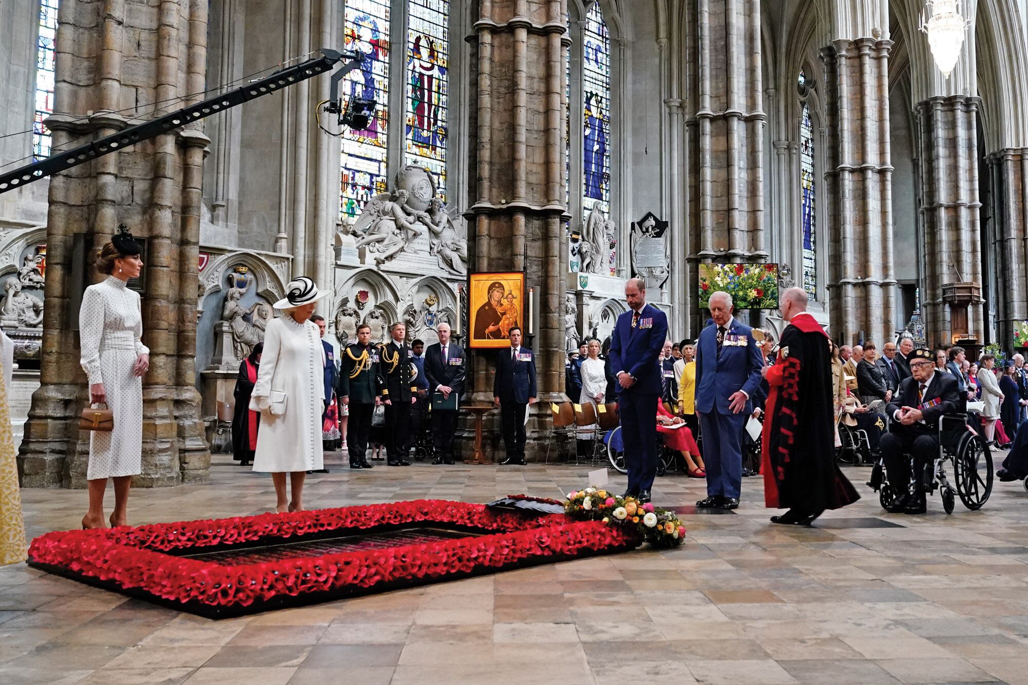 Los príncipes de Gales junto a Carlos III y la reina
Camilla en el interior de la abadía de Westminster,
frente a la tumba del Soldado Desconocido. A un
costado, en sillas de rueda, se lo ve a Ken Hay,
veterano de la Segunda Guerra Mundial, de 99
años.