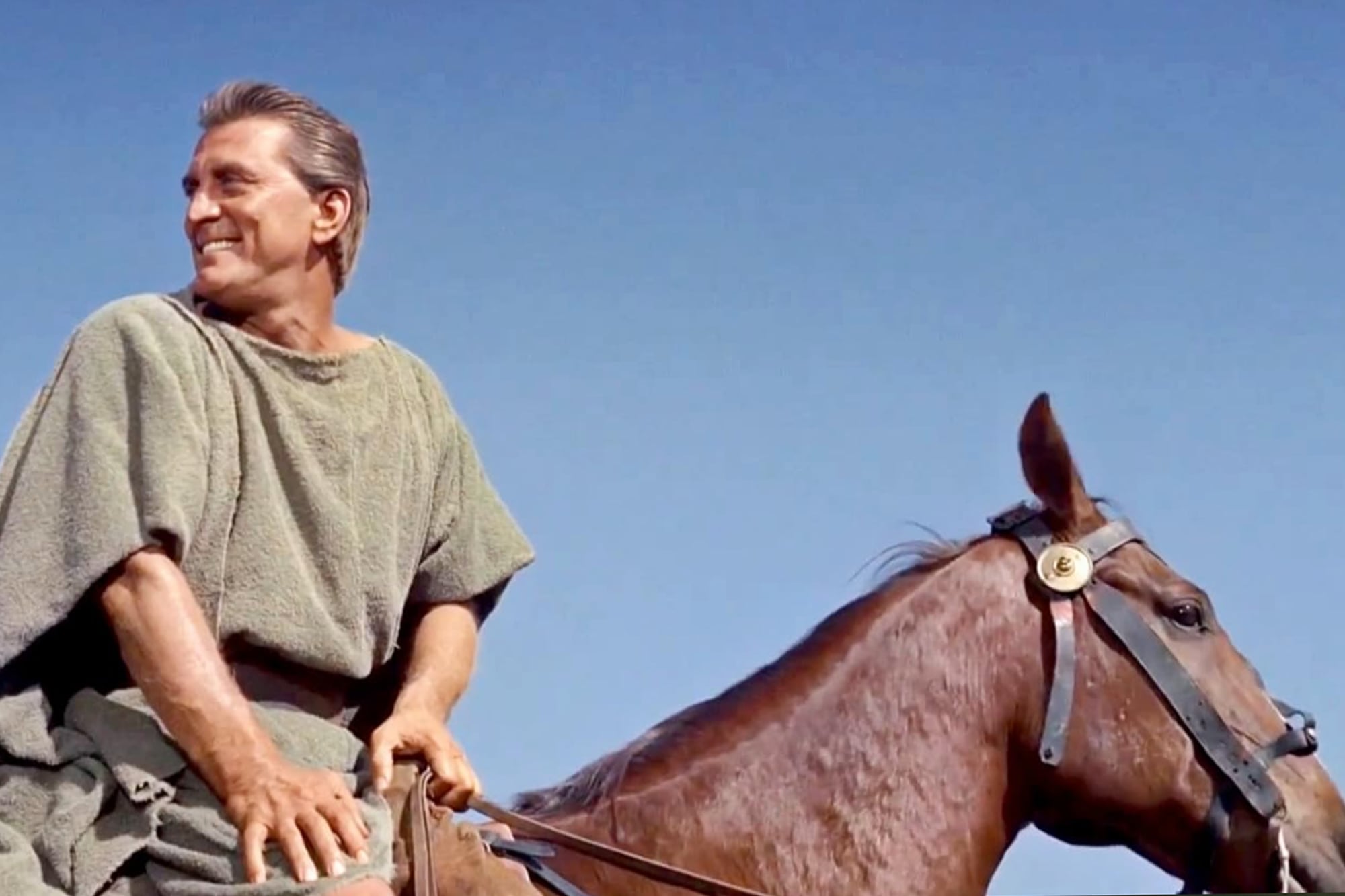 Kirk Doglas, a pura sonrisa, montando a caballo en una escena de la película que se convirtió en un clásico