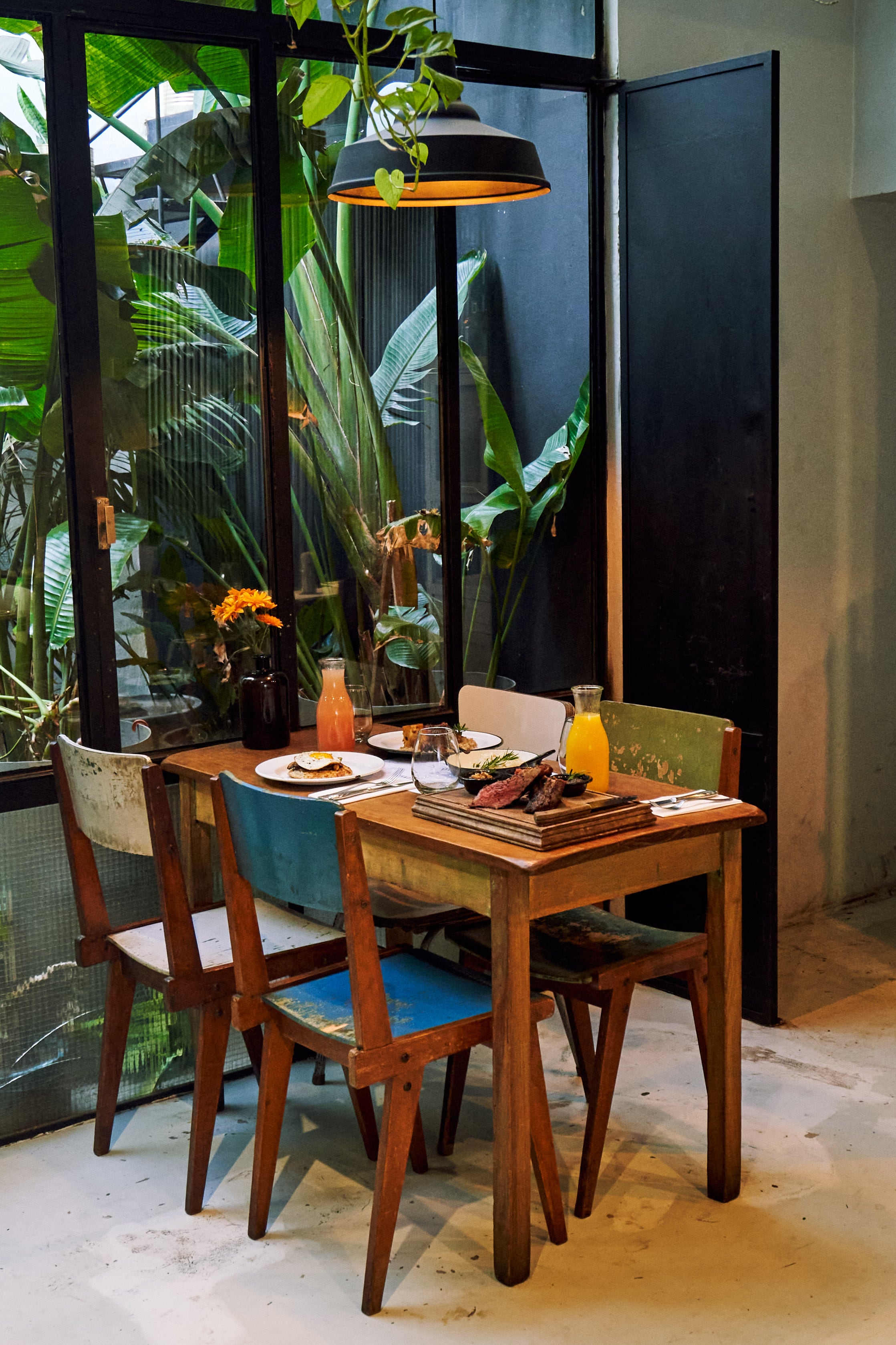 El salón busca transmitir la calidez de una casa, con mesas de madera, sillas de varios estilos, lámparas colgantes, objetos antiguos y muebles del Mercado de Pulgas, que está a cien metros del lugar