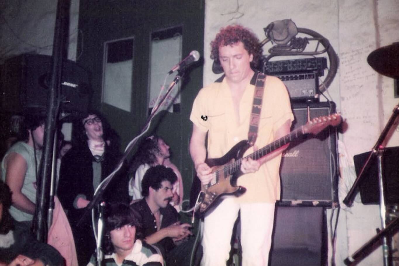 Pablo Guyot, guitarrista emblemático del rock nacional, en el escenario de La Esquina del Sol; atrás, el vidrio de la puerta que rompió