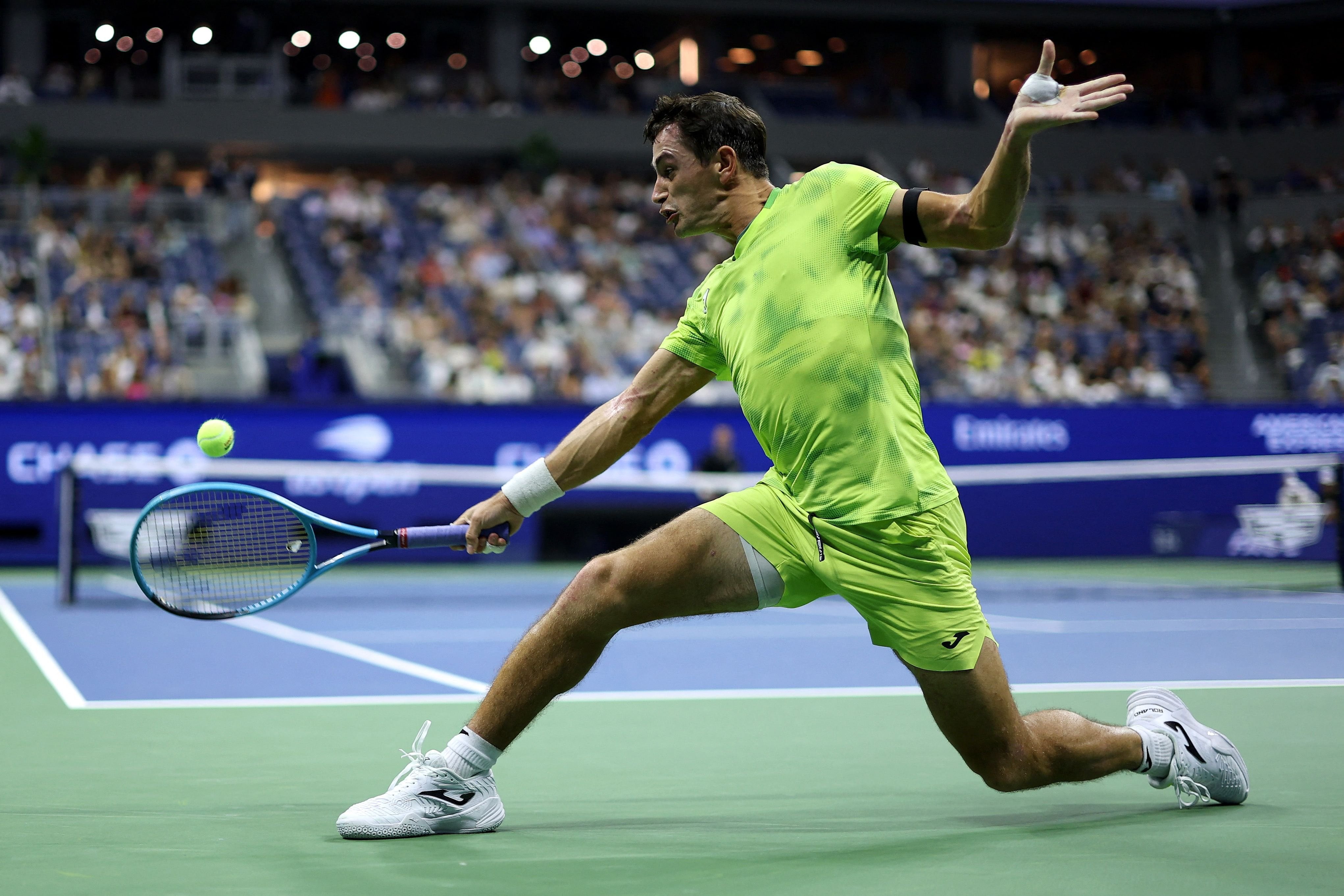El esfuerzo de Mariano Navone para pegar de revés desde el fondo de la cancha (Photo by JULIAN FINNEY / GETTY IMAGES NORTH AMERICA / Getty Images via AFP)