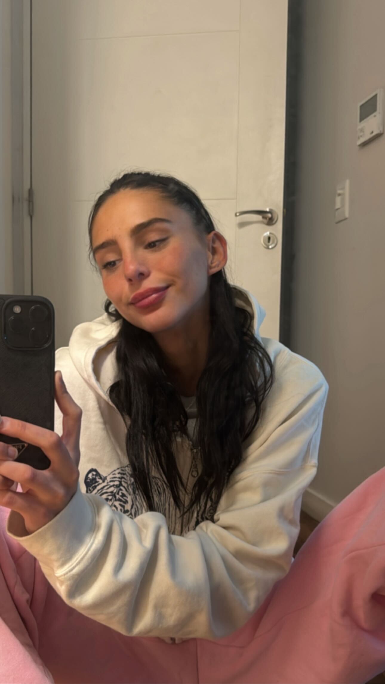 Con un look descontracturado: jogging rosa pastel, buzo blanco, medias y pantuflas, la modelo posó sentada en el suelo con las piernas cruzadas y frente al espejo (Foto: Instagram/@juanitinelli)