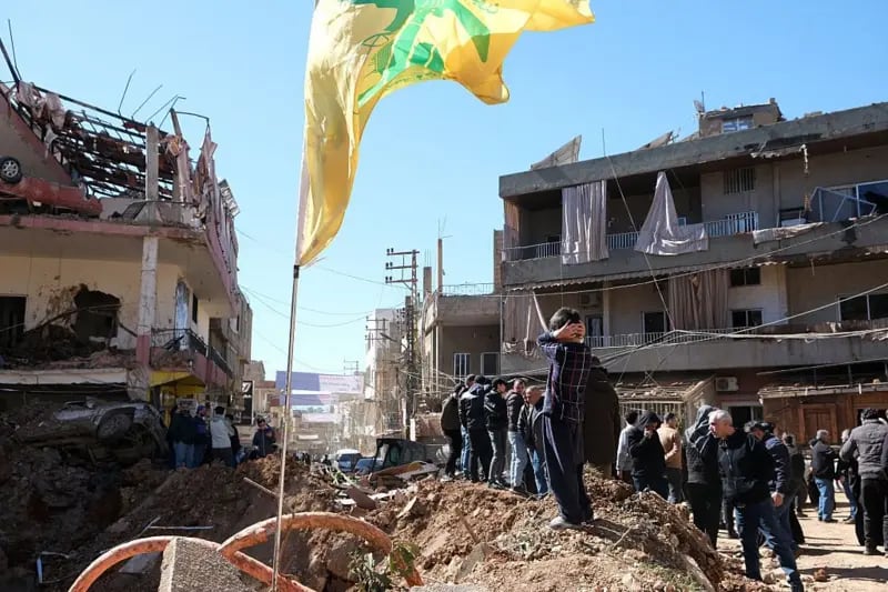 La otra guerra en Medio Oriente: cómo los últimos ataques de Israel evidencian las divisiones y desafíos que enfrenta Líbano 9 Un hombre instala una bandera de Hezbollah en un edificio dañado por ataques israelíes en Líbano