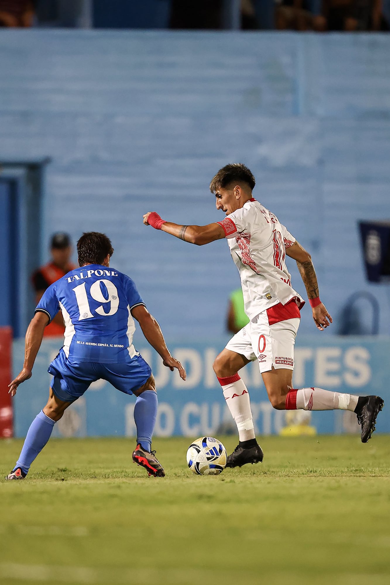 Alan Velasco encara a Nicolás Talpone en el empate entre Estudiantes de Río Cuarto y Argentinos; al momento del penal, el número 10 ya había sido reemplazado